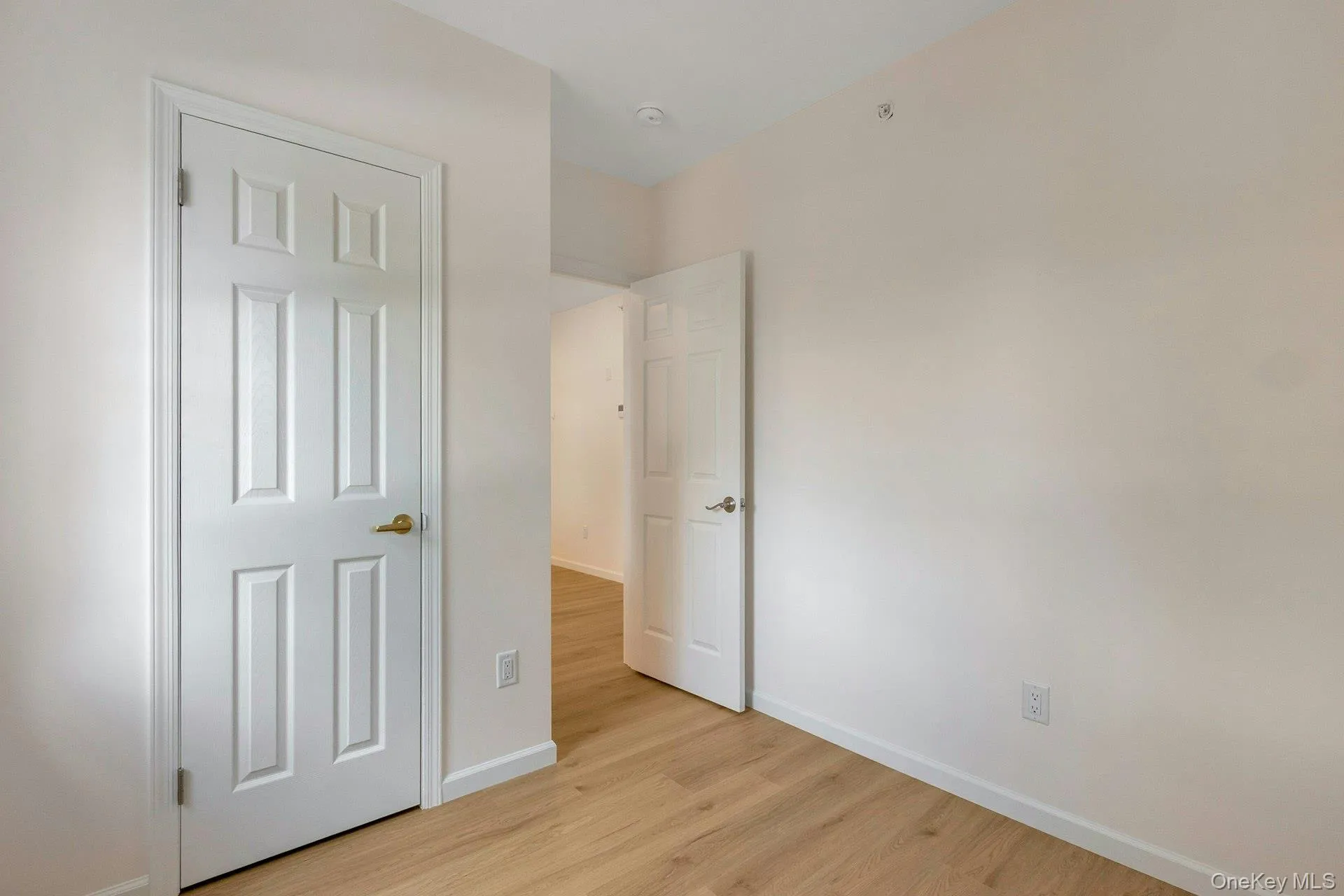 Unfurnished bedroom with baseboards and light wood-style flooring Unfurnished bedroom with baseboards and light wood-style flooring