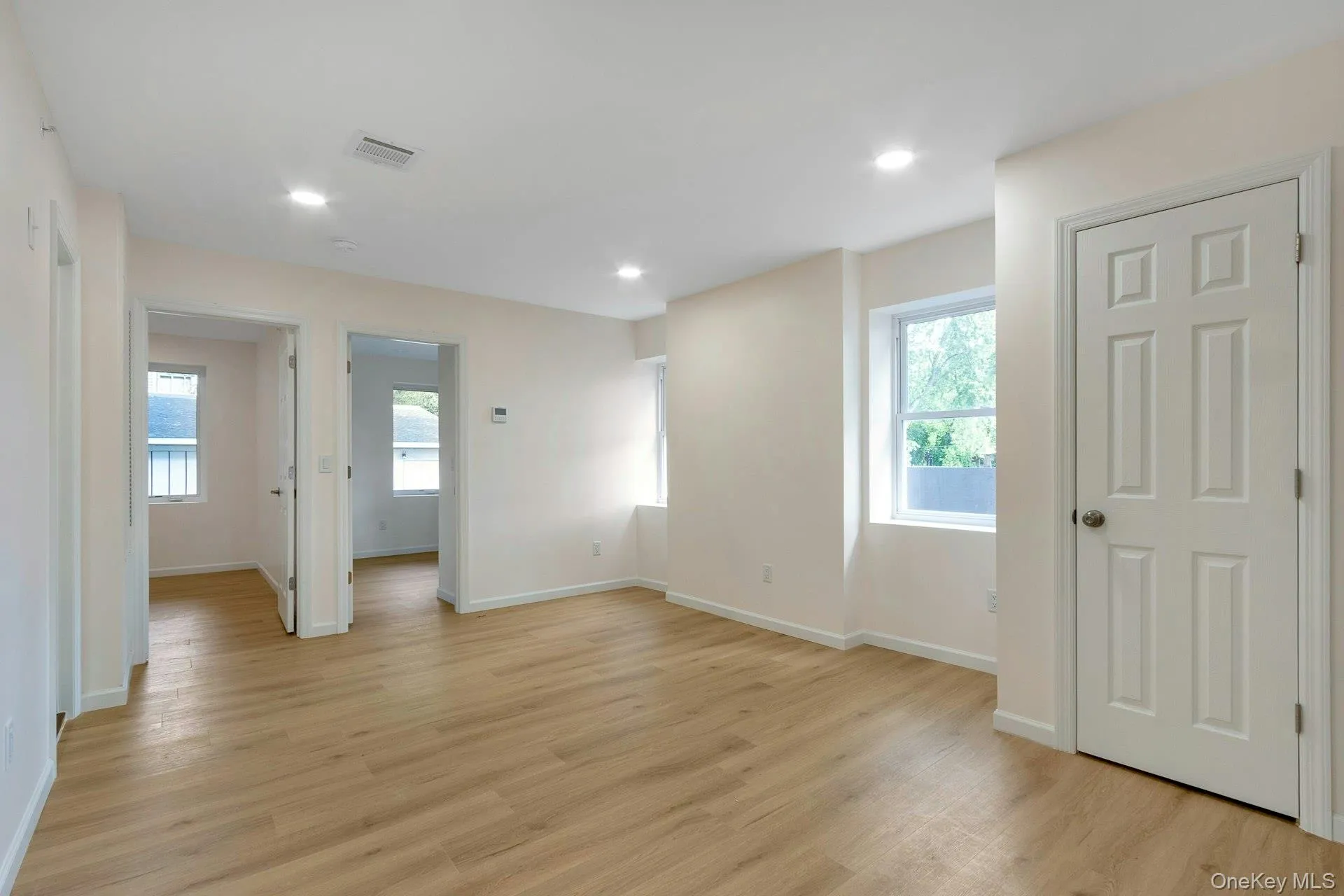 Empty room featuring plenty of natural light, light wood-type flooring, and recessed lighting Empty room featuring plenty of natural light, light wood-type flooring, and recessed lighting