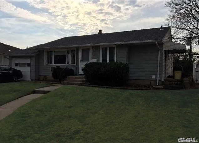 Ranch-style home with a front lawn and an attached garage Ranch-style home with a front lawn and an attached garage