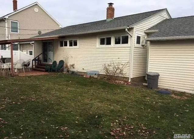 Rear view of house featuring a lawn, a chimney, entry steps, and a shingled roof Rear view of house featuring a lawn, a chimney, entry steps, and a shingled roof