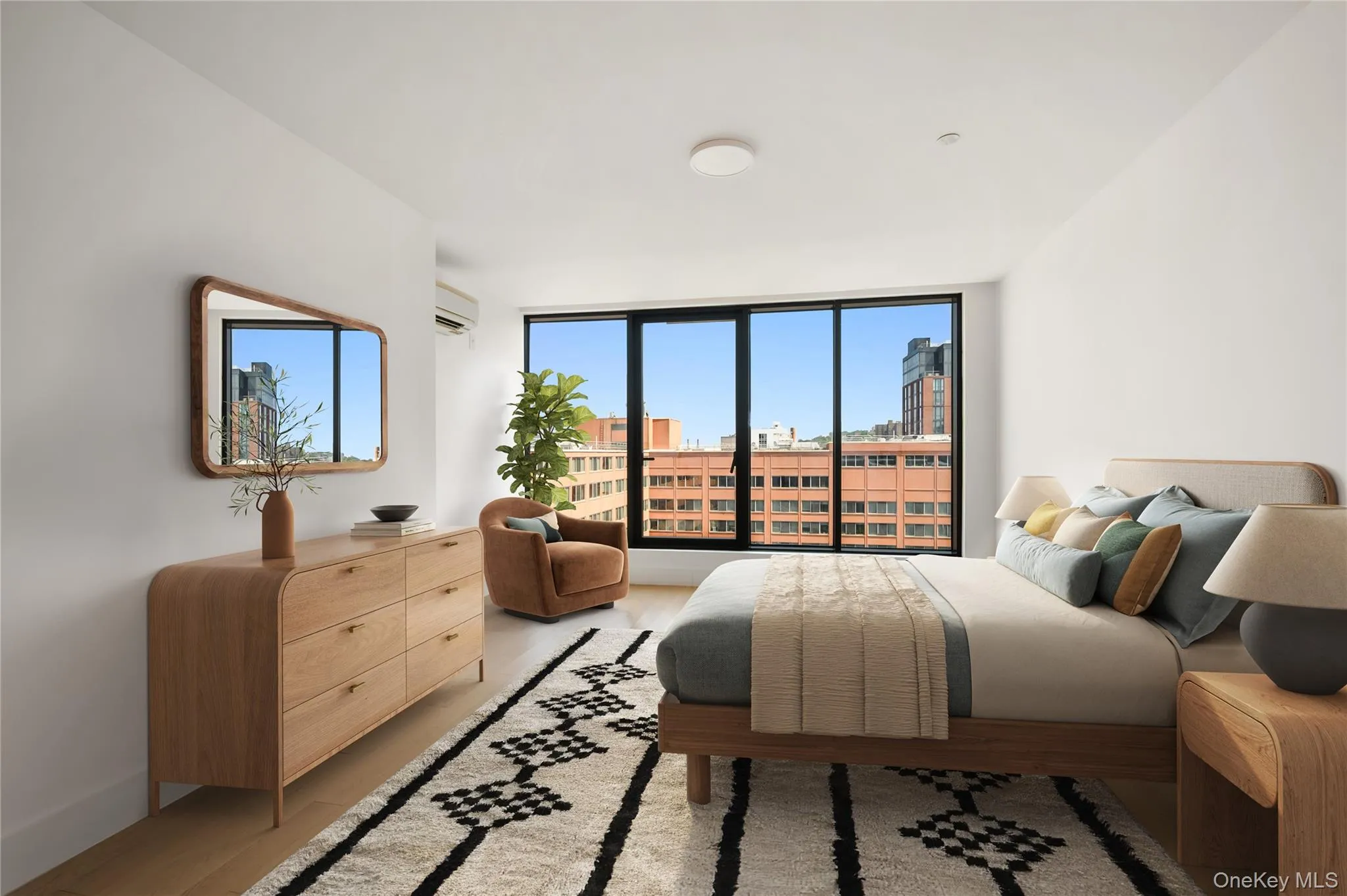Bedroom with light wood-type flooring, a wall of windows, and an AC wall unit Bedroom with light wood-type flooring, a wall of windows, and an AC wall unit