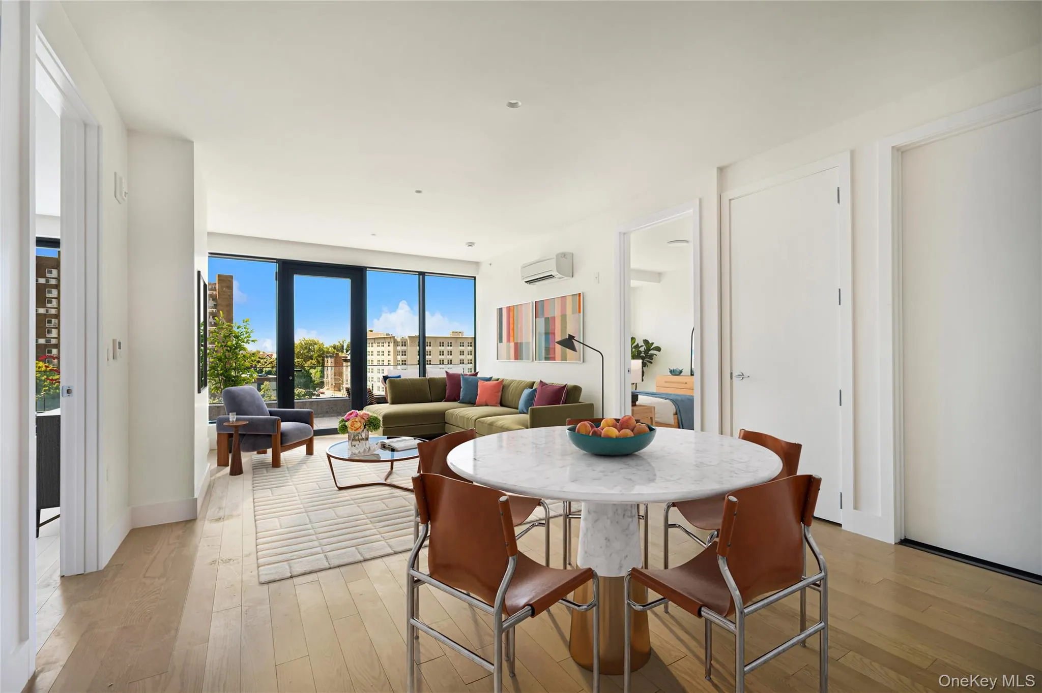 Dining space with light wood-style flooring and an AC wall unit Dining space with light wood-style flooring and an AC wall unit