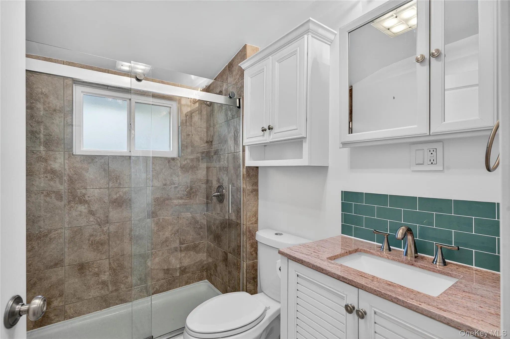 Bathroom with a shower stall, vanity, and decorative backsplash Bathroom with a shower stall, vanity, and decorative backsplash