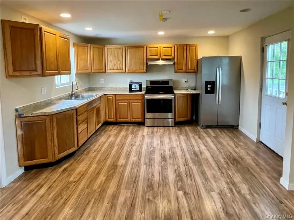 Kitchen with sink, stainless steel appliances, and hardwood / wood-style floors Kitchen with sink, stainless steel appliances, and hardwood / wood-style floors