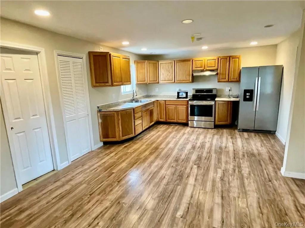 Kitchen featuring sink, stainless steel appliances, and light hardwood / wood-style flooring Kitchen featuring sink, stainless steel appliances, and light hardwood / wood-style flooring