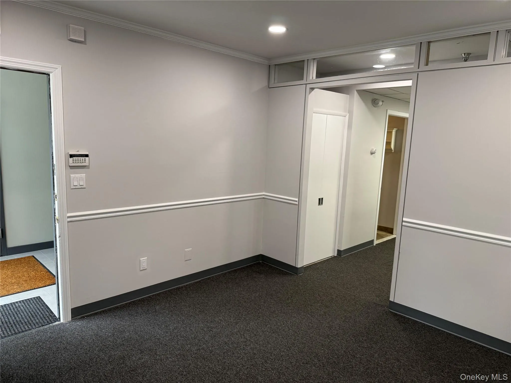 Spare room featuring dark carpet, recessed lighting, and ornamental molding Spare room featuring dark carpet, recessed lighting, and ornamental molding