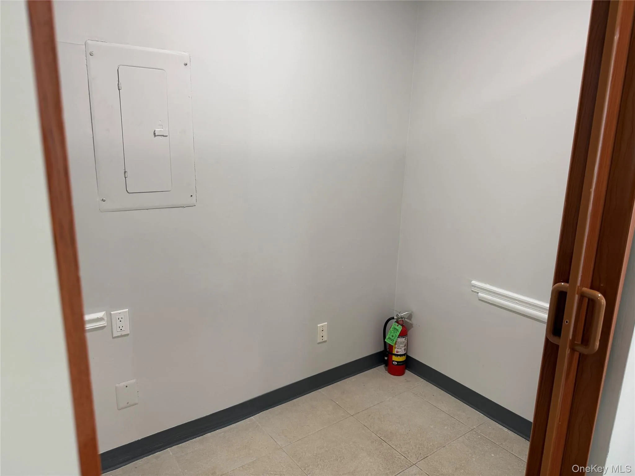 Washroom featuring electric panel and light tile patterned flooring Washroom featuring electric panel and light tile patterned flooring