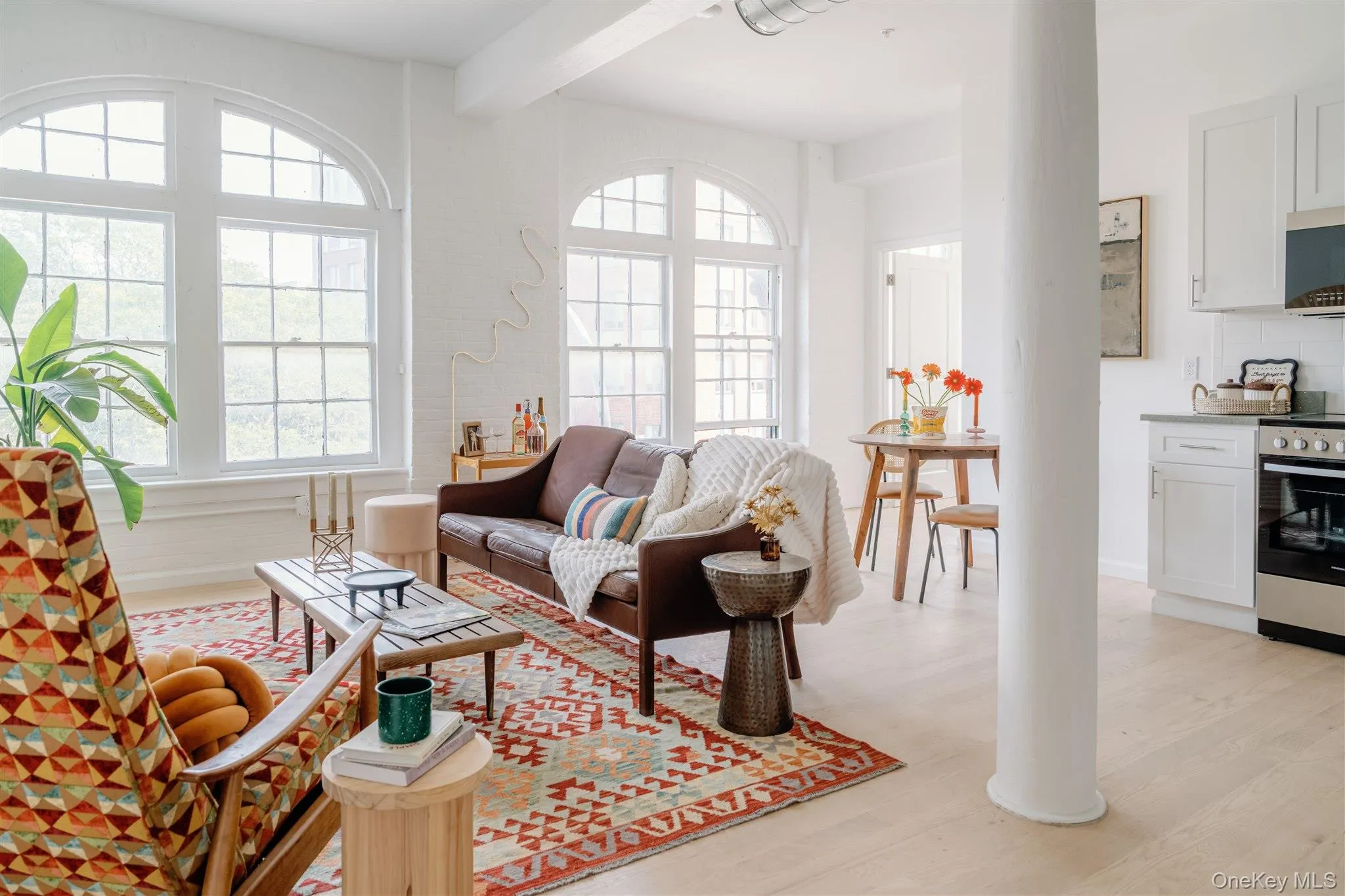 Living room featuring light wood-style floors and beam ceiling Living room featuring light wood-style floors and beam ceiling