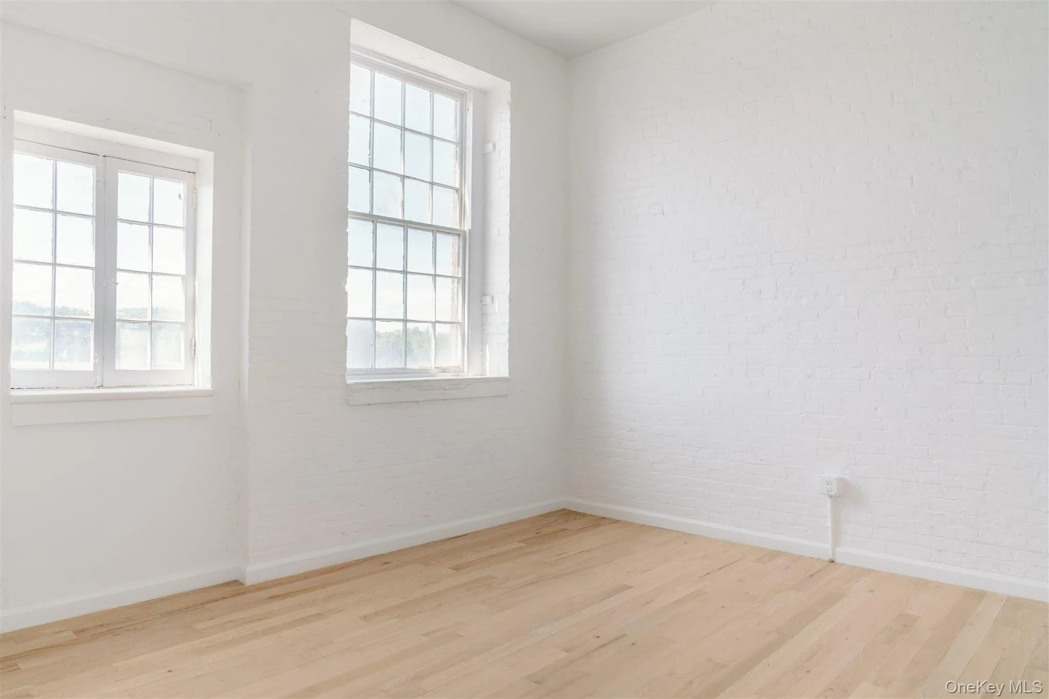 Empty room featuring wood finished floors and baseboards Empty room featuring wood finished floors and baseboards