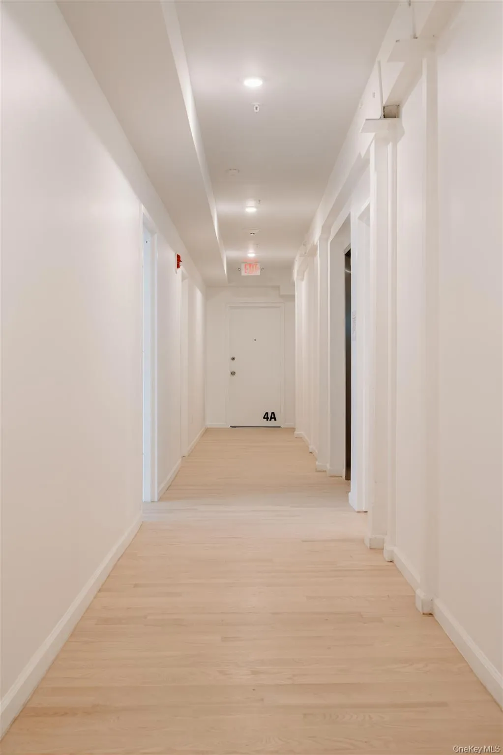Hallway featuring light wood-type flooring and baseboards Hallway featuring light wood-type flooring and baseboards