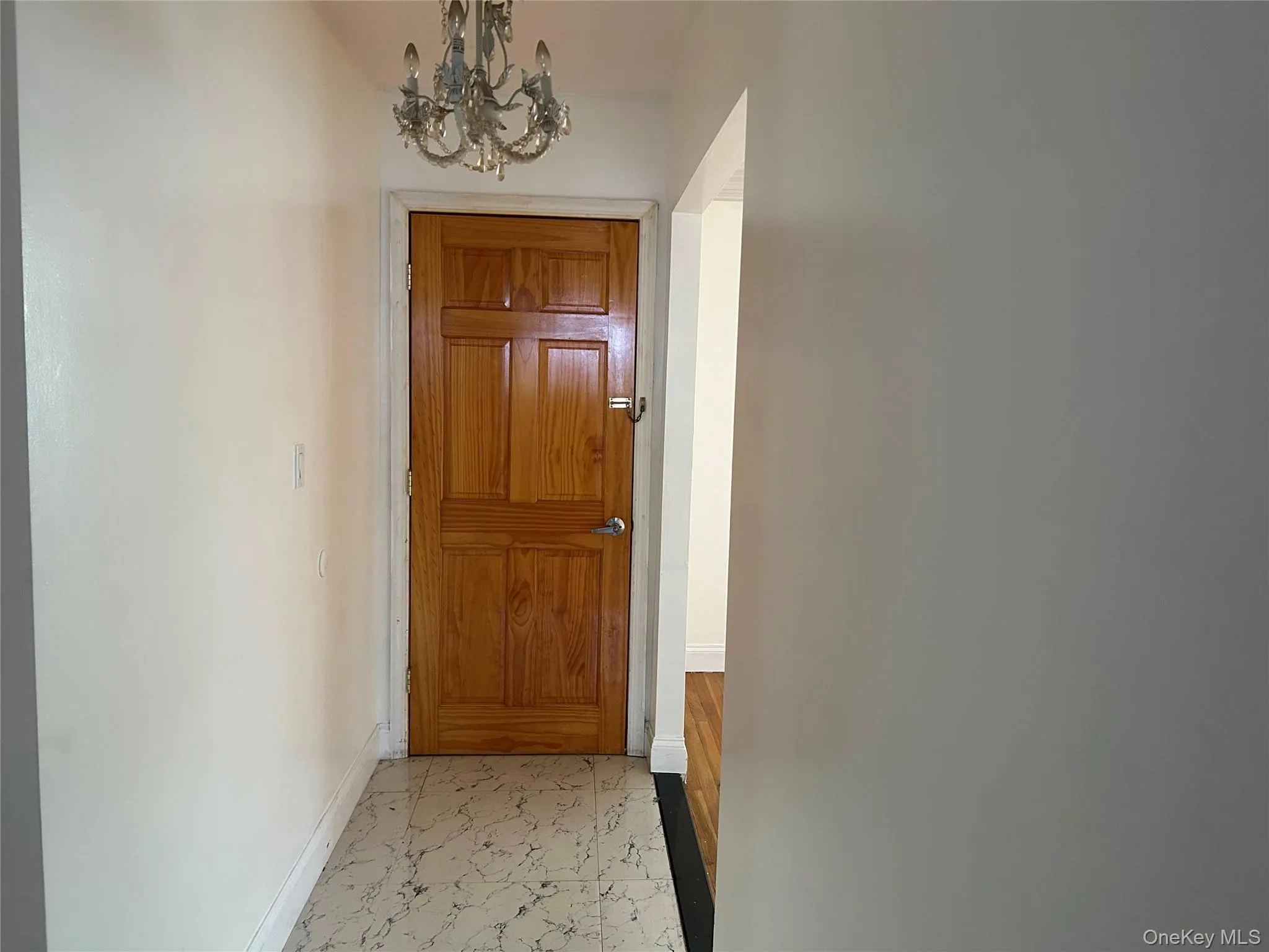 Doorway featuring a chandelier and baseboards Doorway featuring a chandelier and baseboards