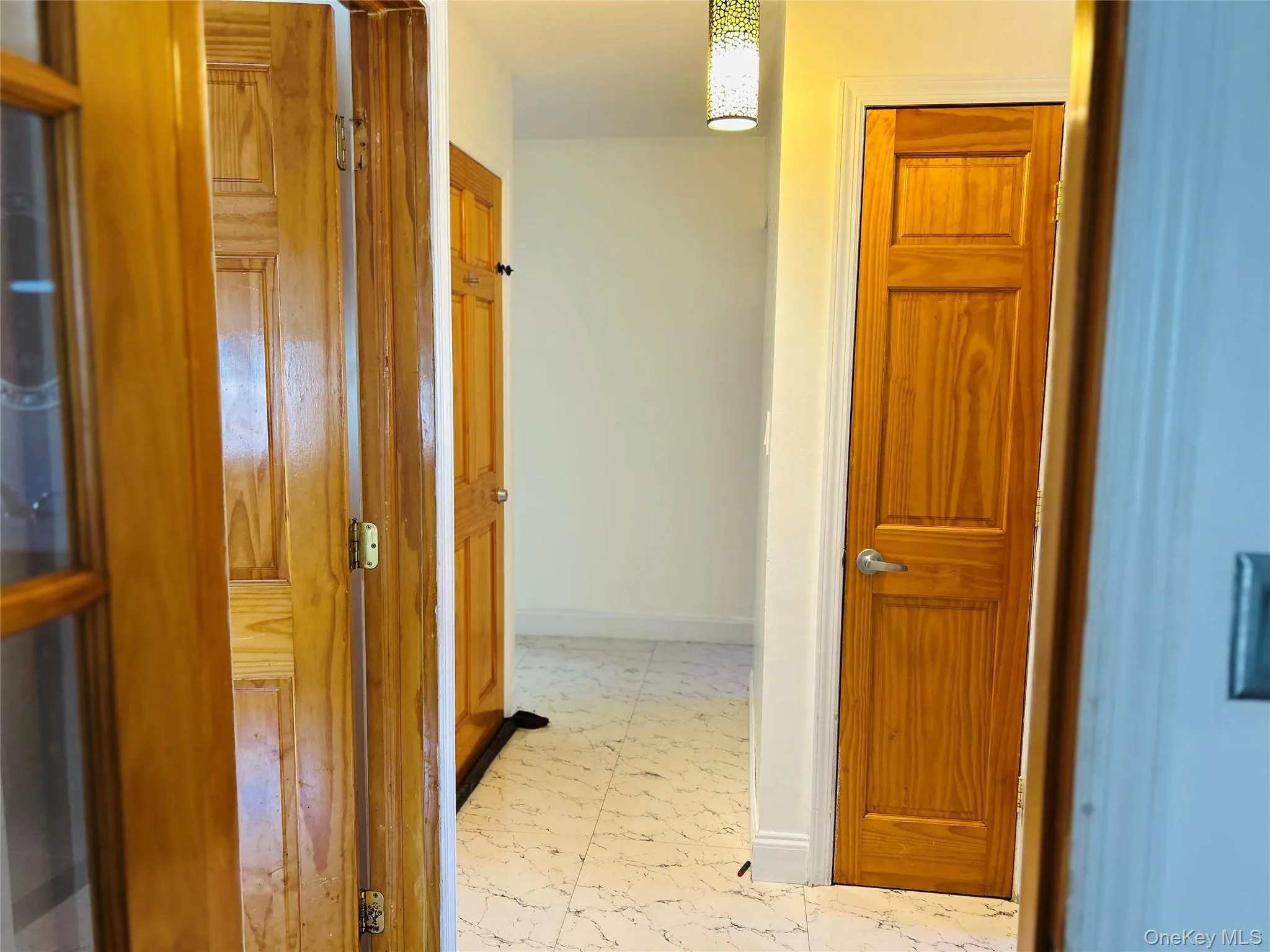 Hall with baseboards and light marble finish floors Hall with baseboards and light marble finish floors