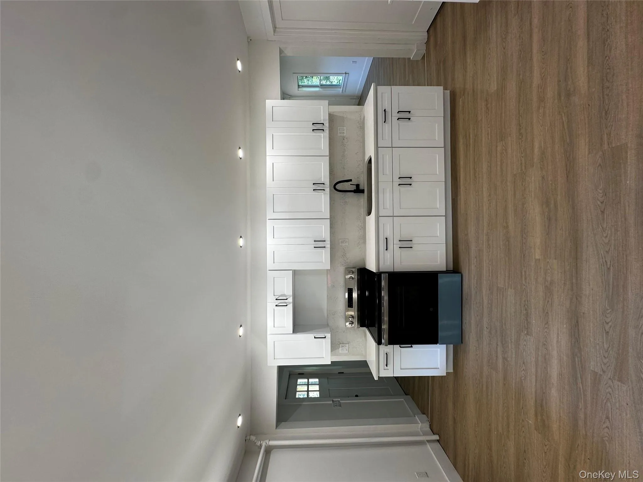 Kitchen featuring white cabinets, stove, decorative backsplash, dark wood finished floors, and recessed lighting Kitchen featuring white cabinets, stove, decorative backsplash, dark wood finished floors, and recessed lighting