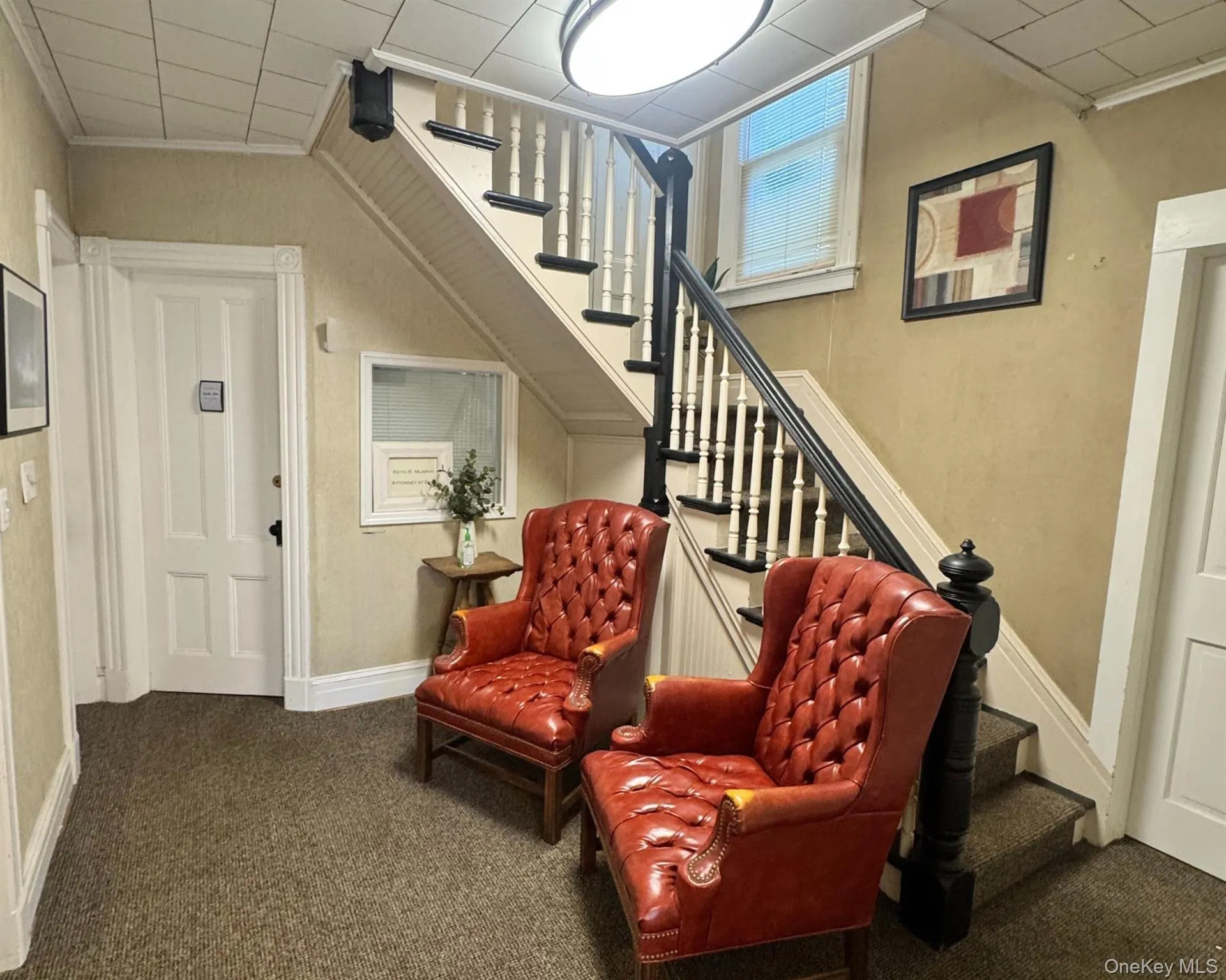 Living area featuring stairs, carpet floors, and crown molding Living area featuring stairs, carpet floors, and crown molding