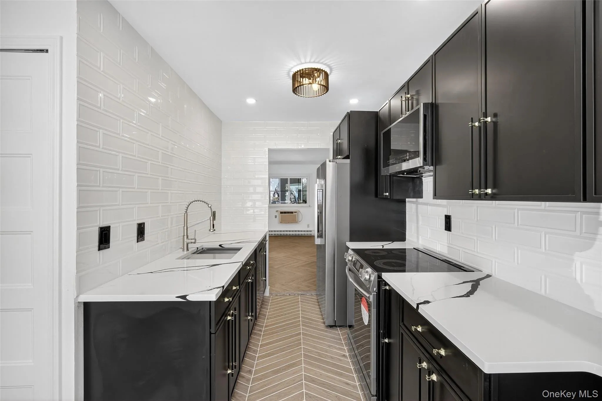 Kitchen with dark cabinets, tasteful backsplash, stainless steel appliances, light stone counters, and recessed lighting Kitchen with dark cabinets, tasteful backsplash, stainless steel appliances, light stone counters, and recessed lighting
