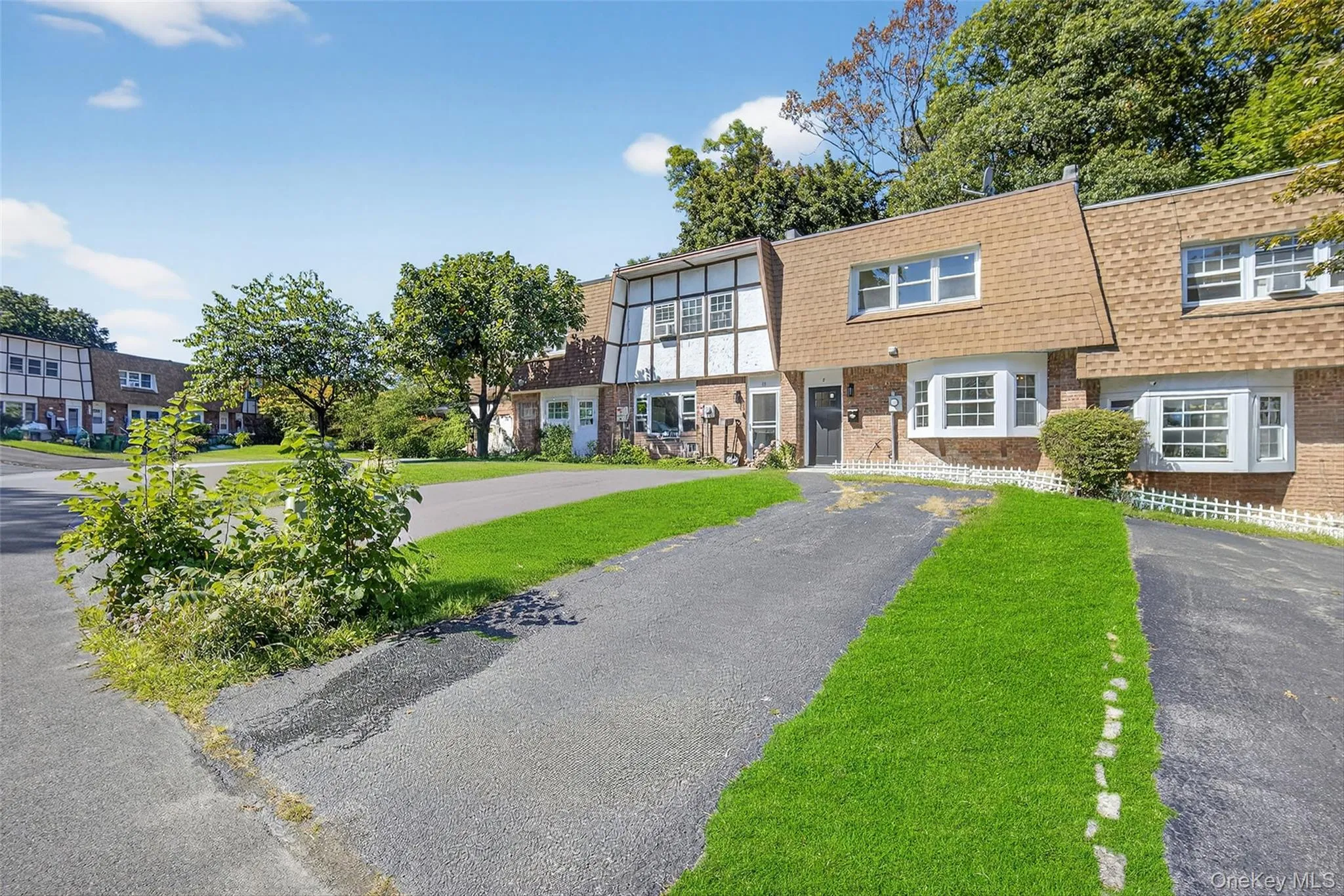 View of front of home featuring mansard roof, a shingled roof, brick siding, a residential view, and a front lawn View of front of home featuring mansard roof, a shingled roof, brick siding, a residential view, and a front lawn