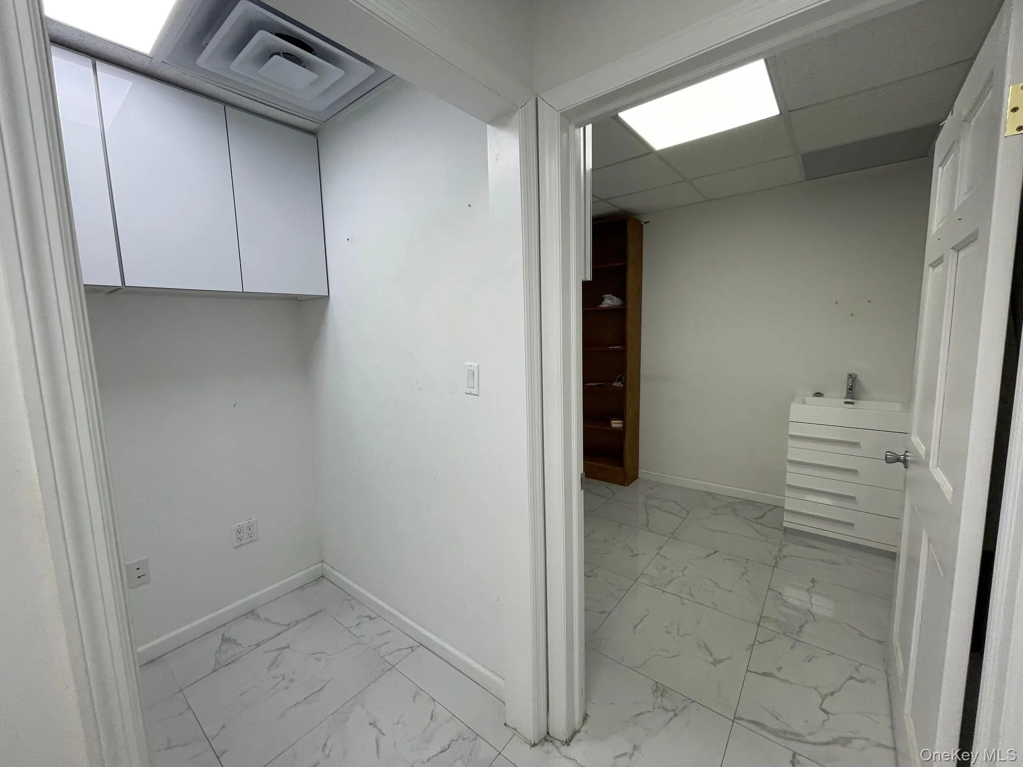 Laundry room featuring light marble finish floors Laundry room featuring light marble finish floors