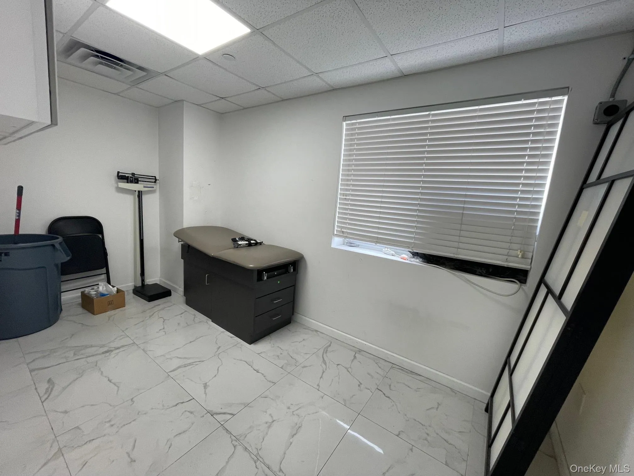 Miscellaneous room featuring light marble finish floors and a paneled ceiling Miscellaneous room featuring light marble finish floors and a paneled ceiling