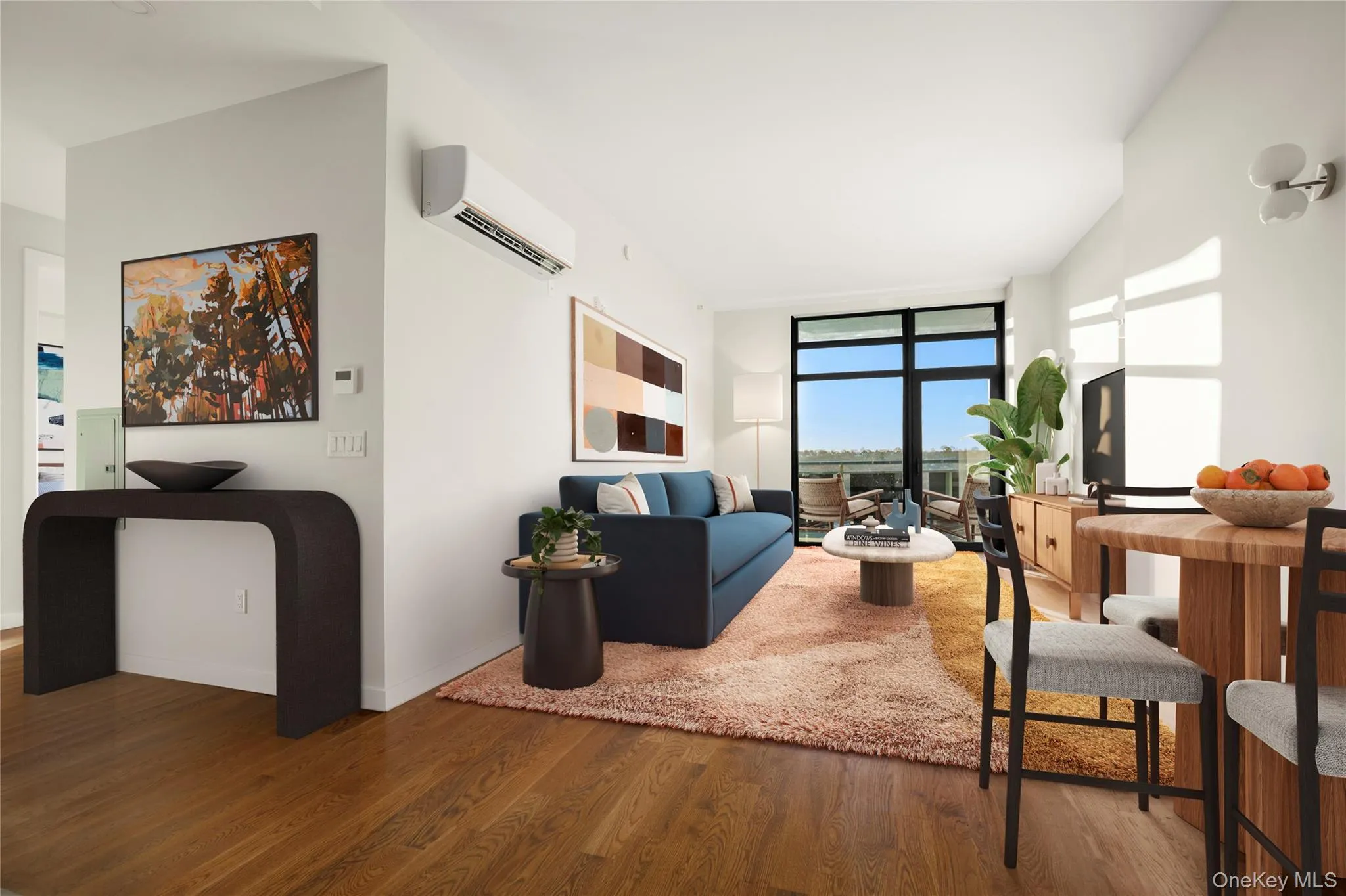 Living room with hardwood / wood-style floors, an AC wall unit, and expansive windows Living room with hardwood / wood-style floors, an AC wall unit, and expansive windows