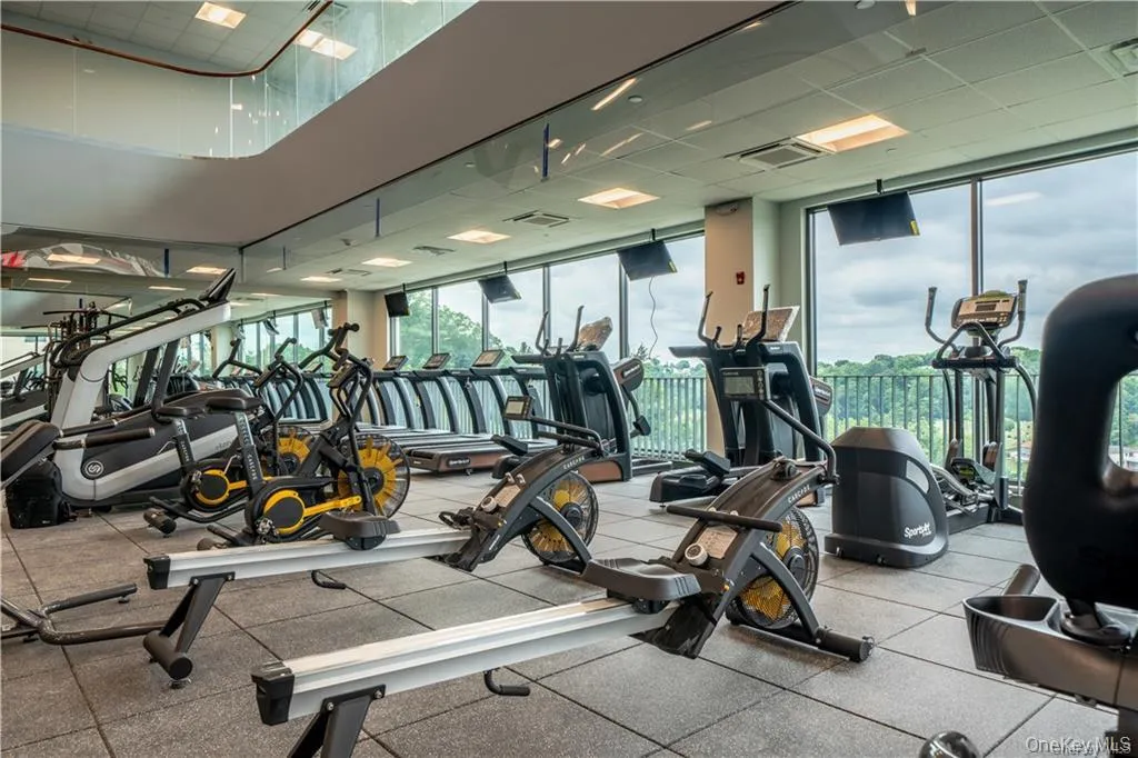 Workout area featuring visible vents, a drop ceiling, and a wall of windows Workout area featuring visible vents, a drop ceiling, and a wall of windows