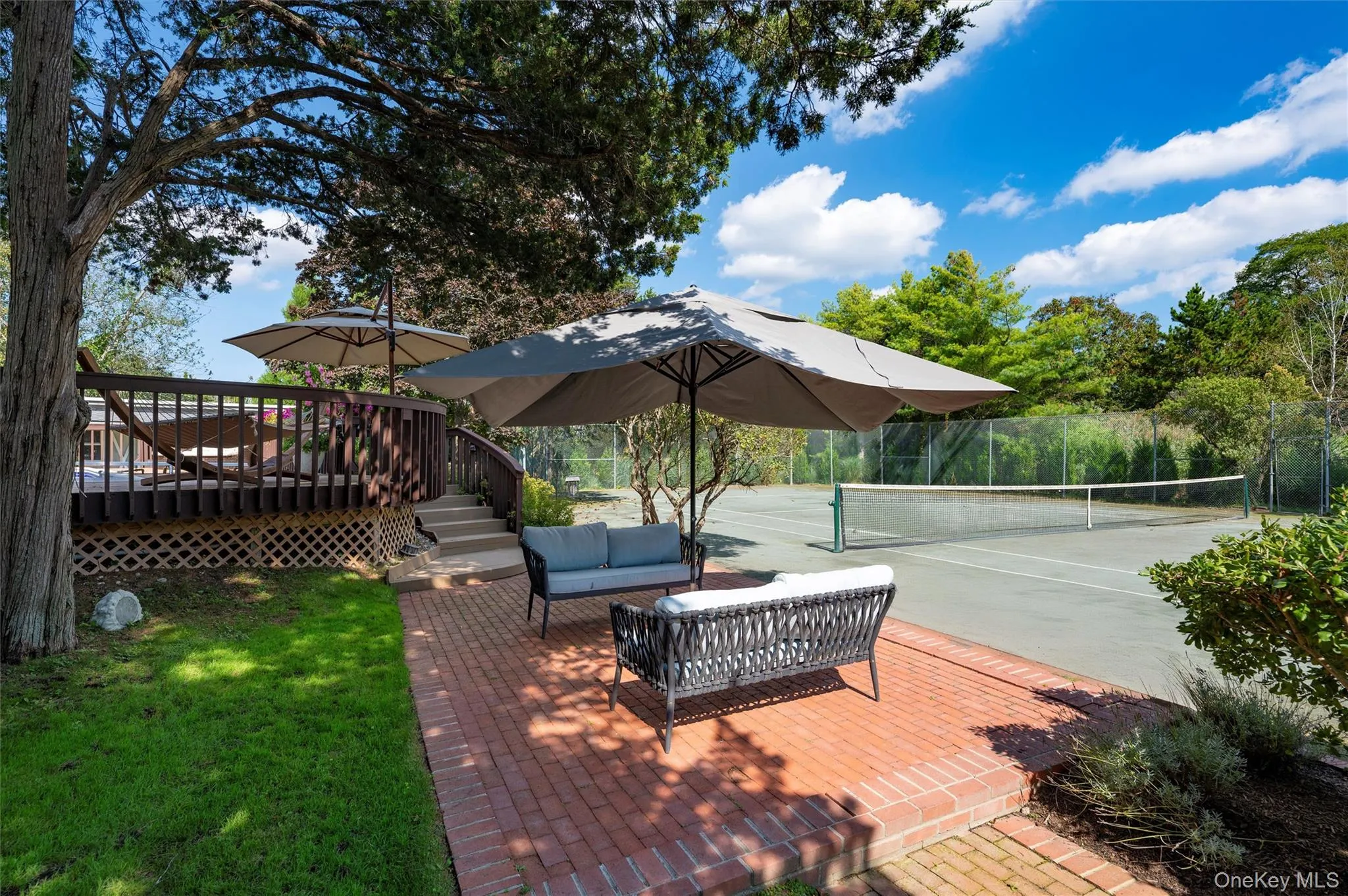Deck with a tennis court, a patio, and an outdoor hangout area Deck with a tennis court, a patio, and an outdoor hangout area