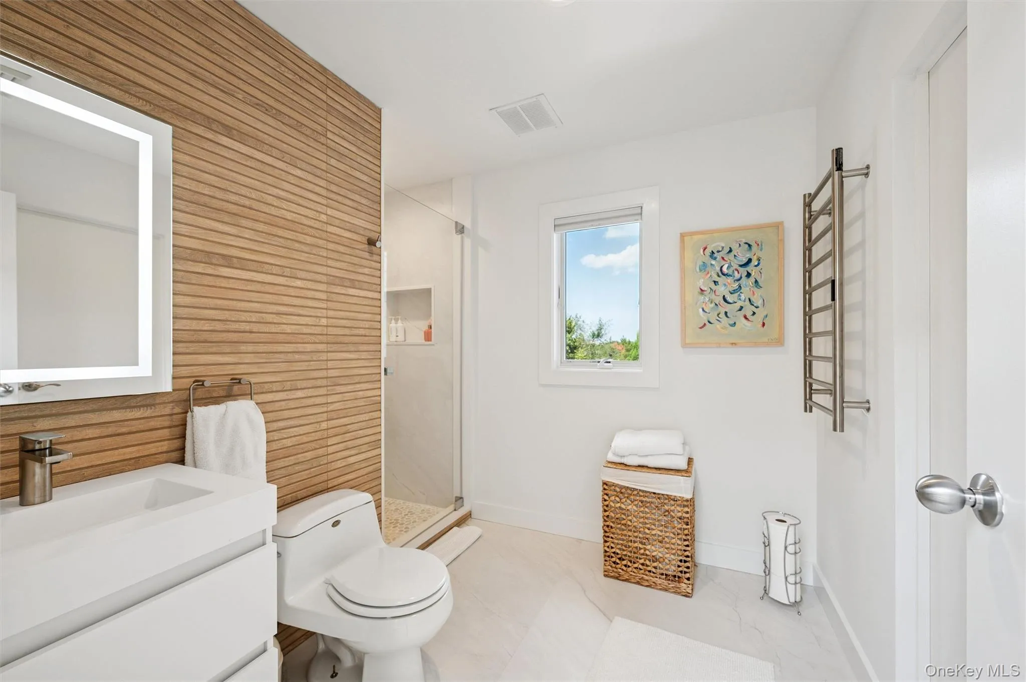 Bathroom with a stall shower, vanity, a towel warmer, and wooden walls Bathroom with a stall shower, vanity, a towel warmer, and wooden walls