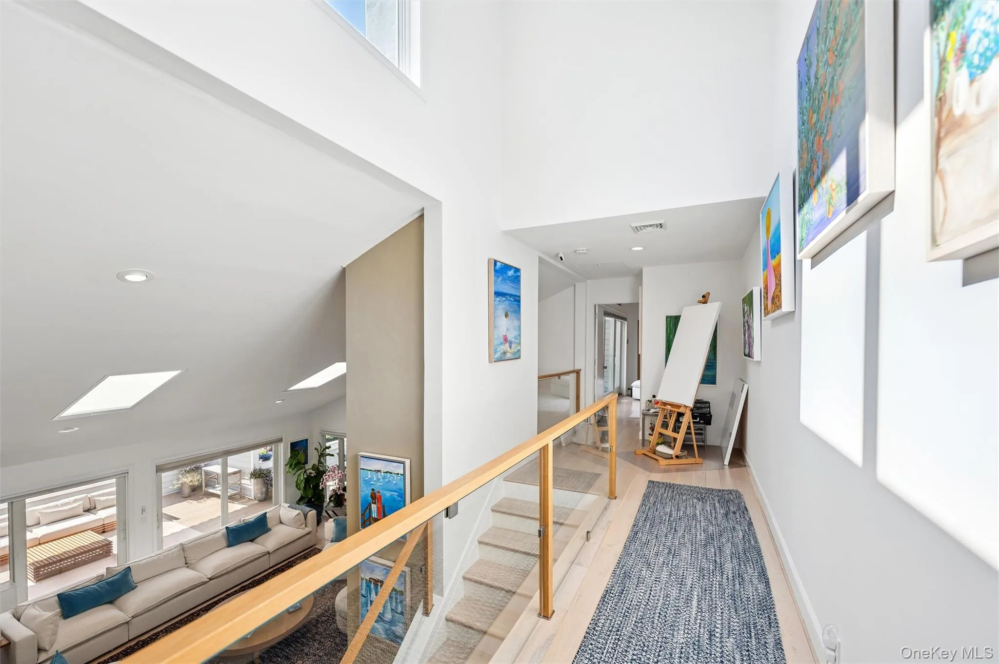 Corridor with a towering ceiling, light wood finished floors, and recessed lighting Corridor with a towering ceiling, light wood finished floors, and recessed lighting