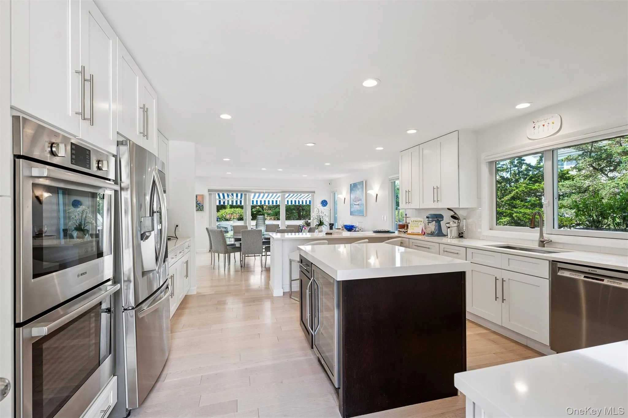 Kitchen with stainless steel appliances, white cabinetry, a peninsula, a center island, and recessed lighting Kitchen with stainless steel appliances, white cabinetry, a peninsula, a center island, and recessed lighting