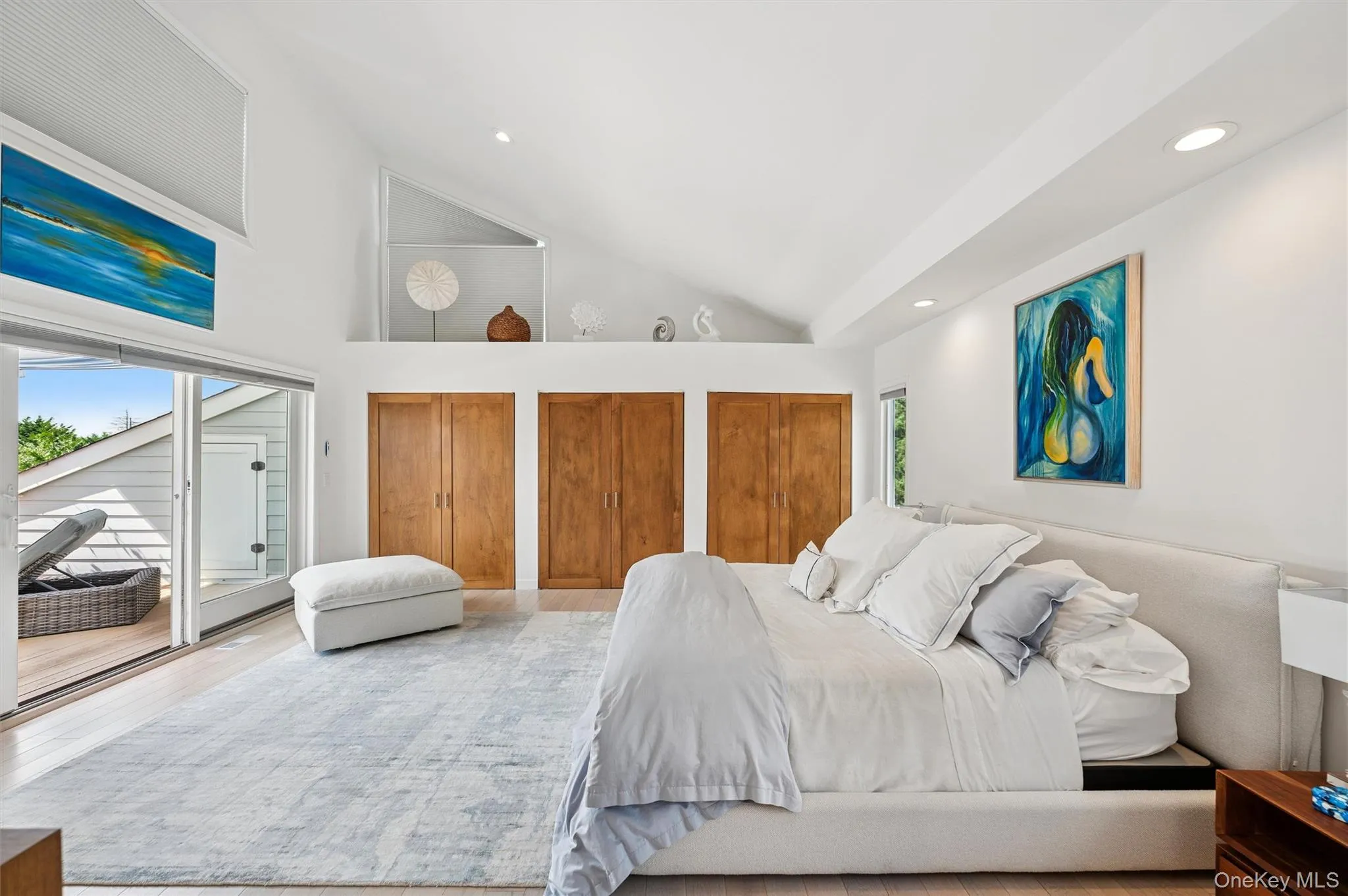 Bedroom with multiple closets, access to exterior, high vaulted ceiling, recessed lighting, and wood finished floors Bedroom with multiple closets, access to exterior, high vaulted ceiling, recessed lighting, and wood finished floors