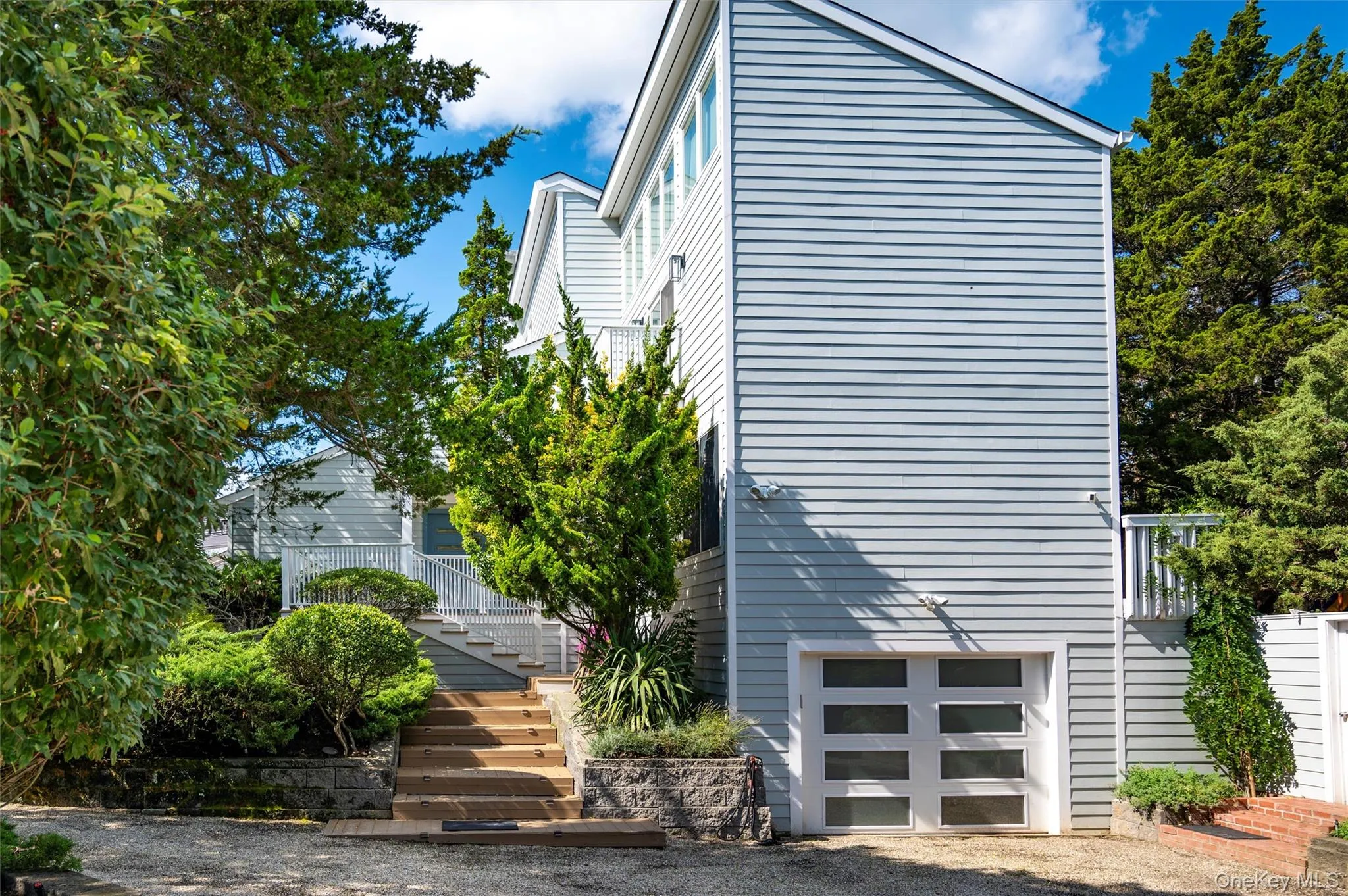 View of property exterior featuring a garage and stairs View of property exterior featuring a garage and stairs