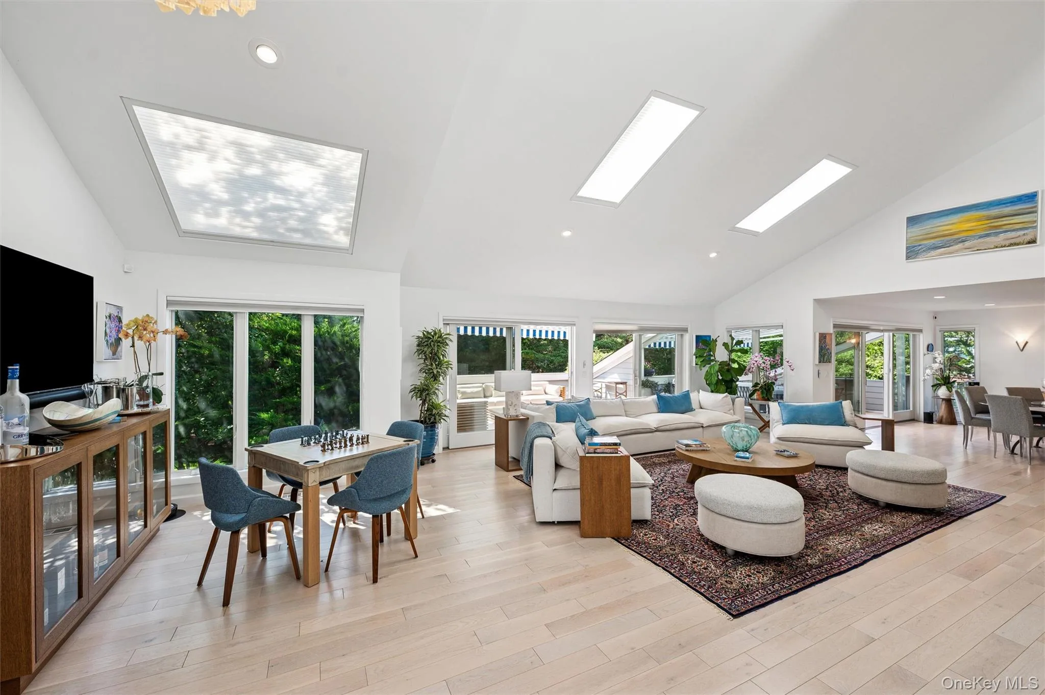 Living area featuring high vaulted ceiling, recessed lighting, and light wood finished floors Living area featuring high vaulted ceiling, recessed lighting, and light wood finished floors