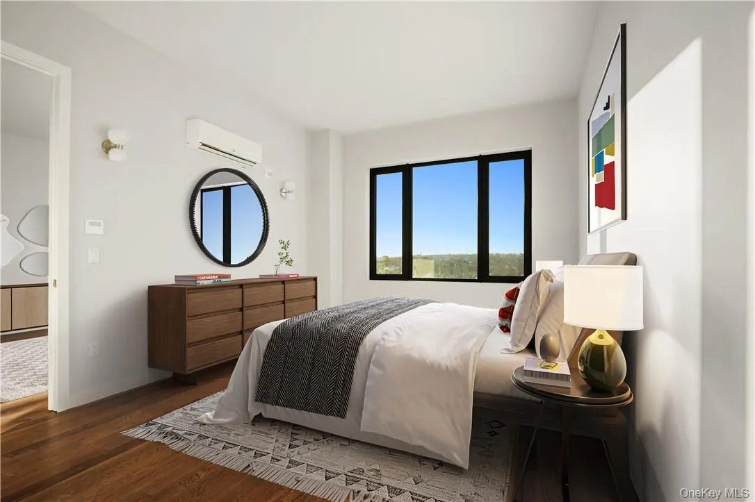 Bedroom with dark wood-type flooring and a wall mounted air conditioner Bedroom with dark wood-type flooring and a wall mounted air conditioner