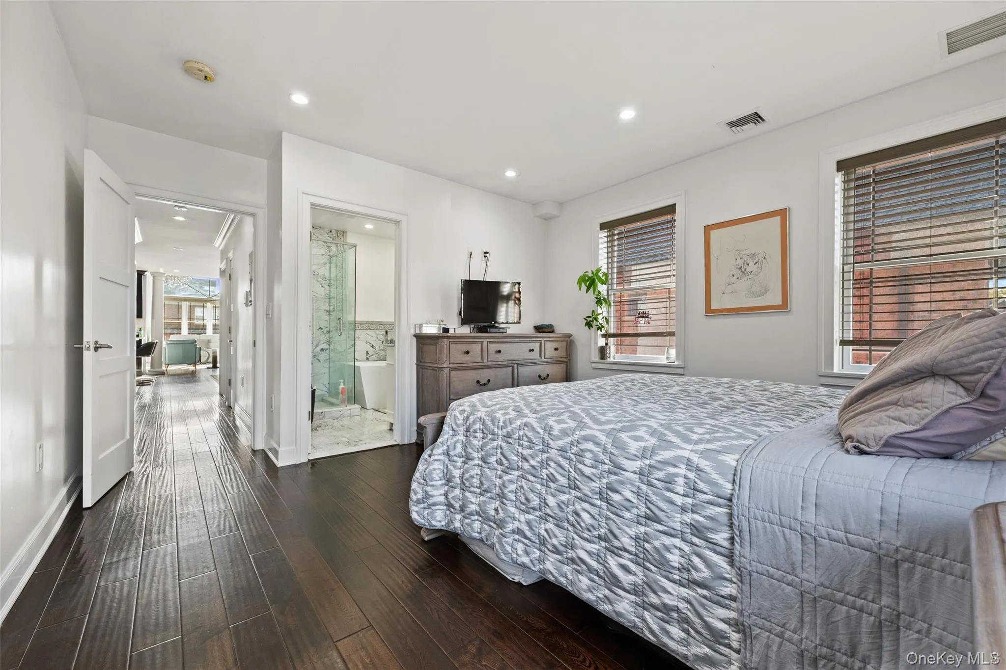 Bedroom featuring dark wood-type flooring, recessed lighting, and connected bathroom Bedroom featuring dark wood-type flooring, recessed lighting, and connected bathroom