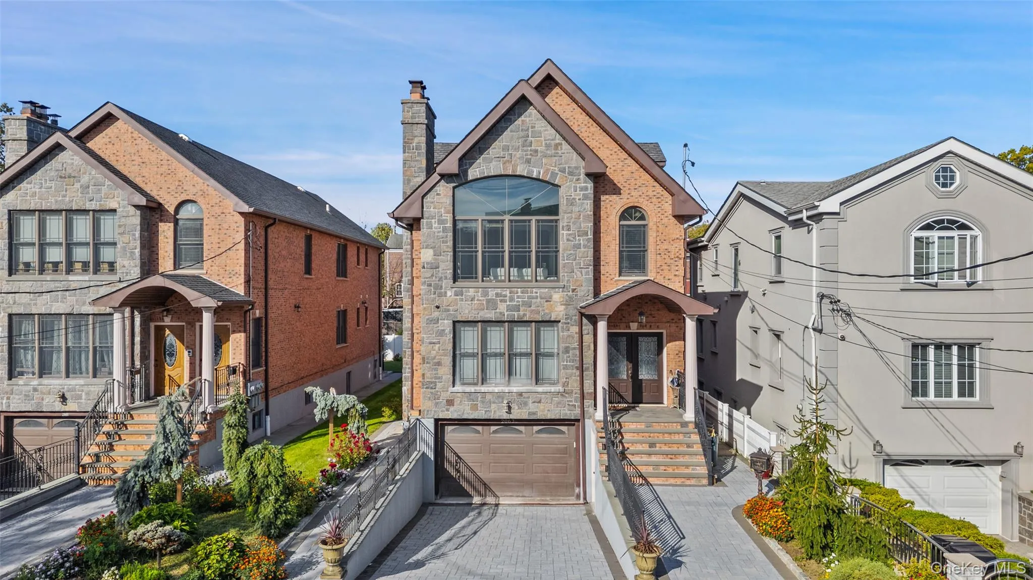 French country inspired facade with stone siding, an attached garage, decorative driveway, and a chimney French country inspired facade with stone siding, an attached garage, decorative driveway, and a chimney