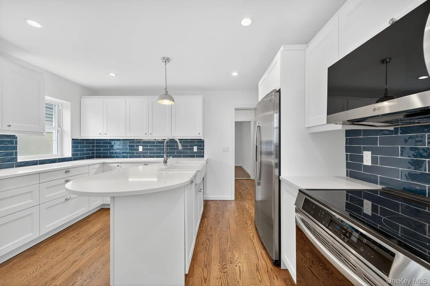 Kitchen featuring stainless steel appliances, pendant lighting, tasteful backsplash, white cabinets, and recessed lighting Kitchen featuring stainless steel appliances, pendant lighting, tasteful backsplash, white cabinets, and recessed lighting