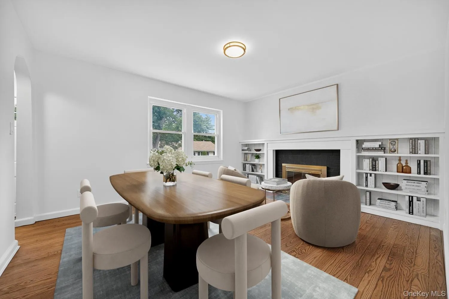 Virtually Staged - Dining area with a fireplace, wood finished floors, and arched walkways Virtually Staged - Dining area with a fireplace, wood finished floors, and arched walkways