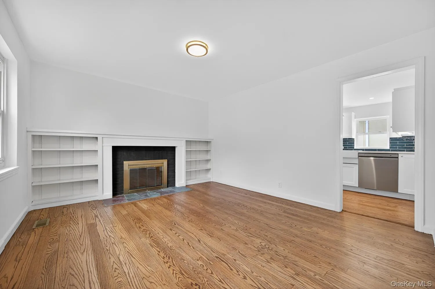living room featuring a wood burning fireplace and built in book cases living room featuring a wood burning fireplace and built in book cases