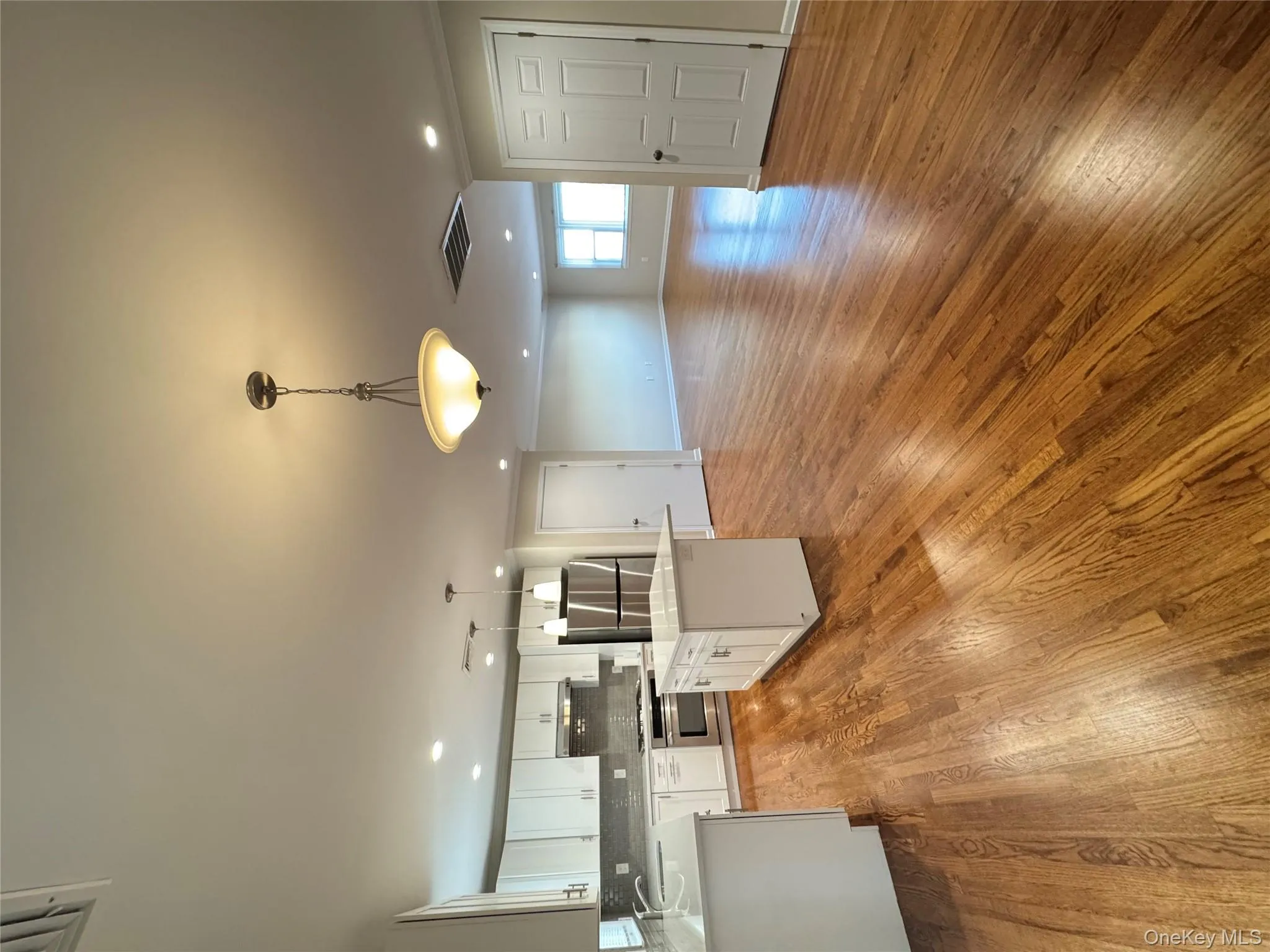 Kitchen with a center island, pendant lighting, open floor plan, white cabinets, and fridge Kitchen with a center island, pendant lighting, open floor plan, white cabinets, and fridge