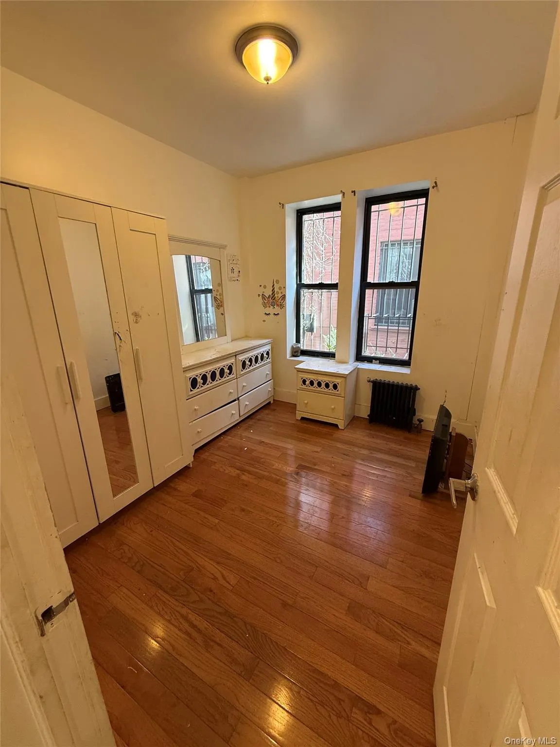 Unfurnished room with dark wood finished floors and radiator heating unit Unfurnished room with dark wood finished floors and radiator heating unit