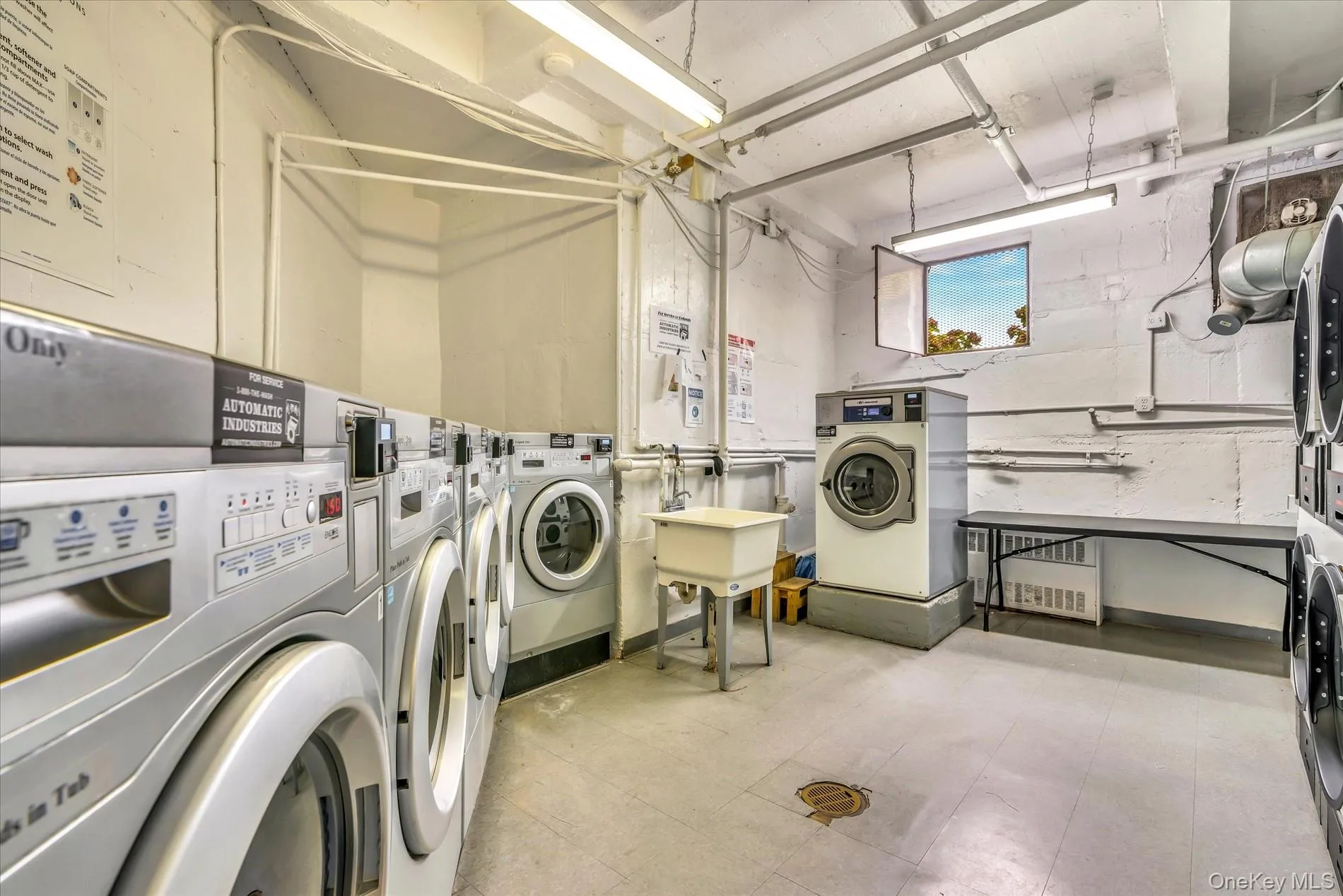 Shared laundry room with washing machine and dryer and light flooring Shared laundry room with washing machine and dryer and light flooring