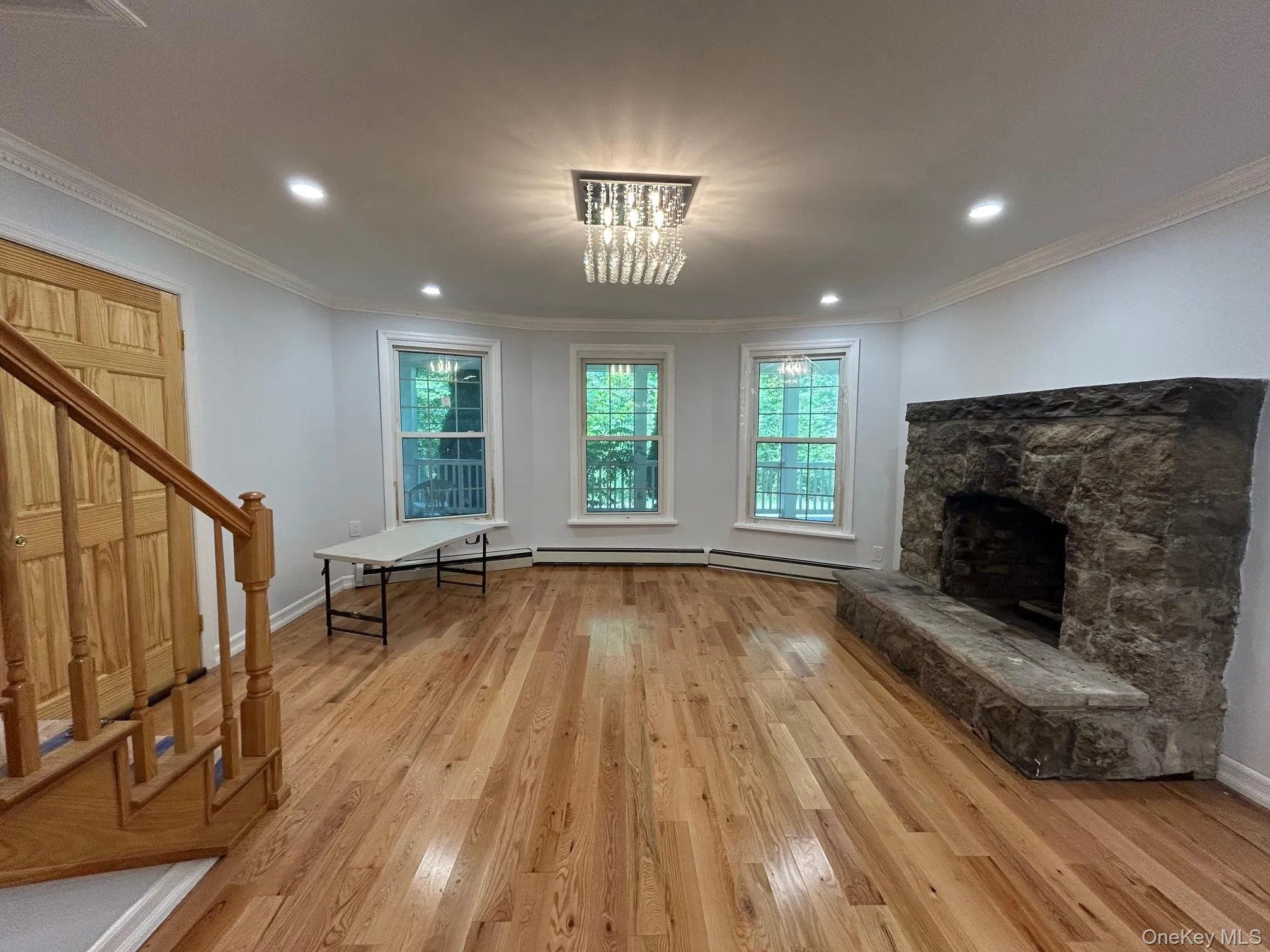 Unfurnished living room featuring healthy amount of natural light, crown molding, a fireplace, light wood-type flooring, and recessed lighting Unfurnished living room featuring healthy amount of natural light, crown molding, a fireplace, light wood-type flooring, and recessed lighting