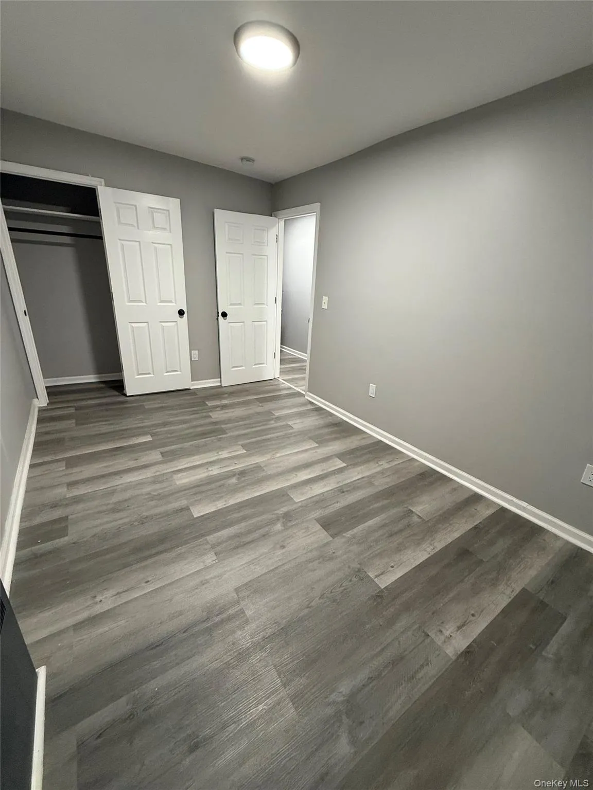 Unfurnished bedroom featuring wood finished floors and a closet Unfurnished bedroom featuring wood finished floors and a closet