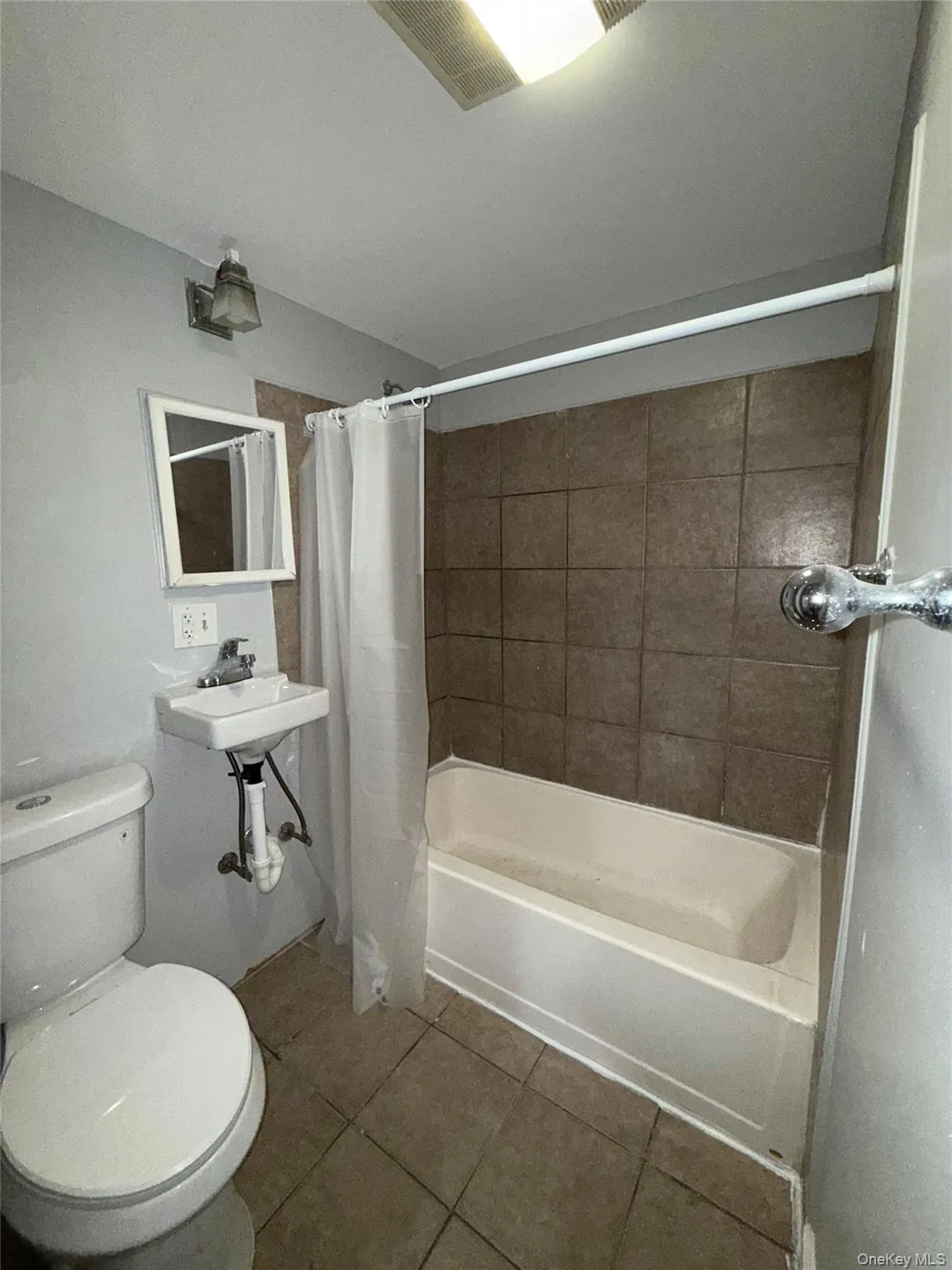 Full bath featuring tile patterned flooring and shower / tub combo Full bath featuring tile patterned flooring and shower / tub combo