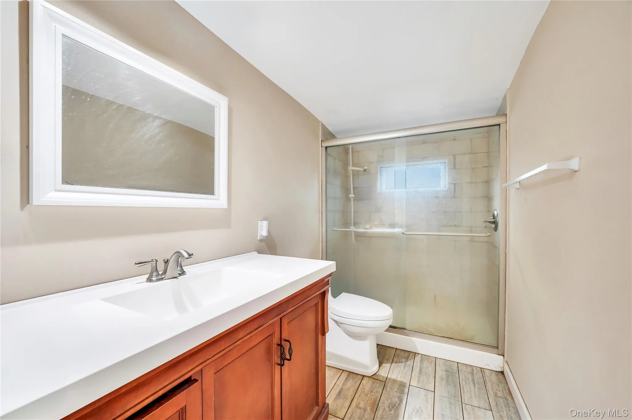 Full bathroom featuring vanity, light wood-style floors, and a stall shower Full bathroom featuring vanity, light wood-style floors, and a stall shower