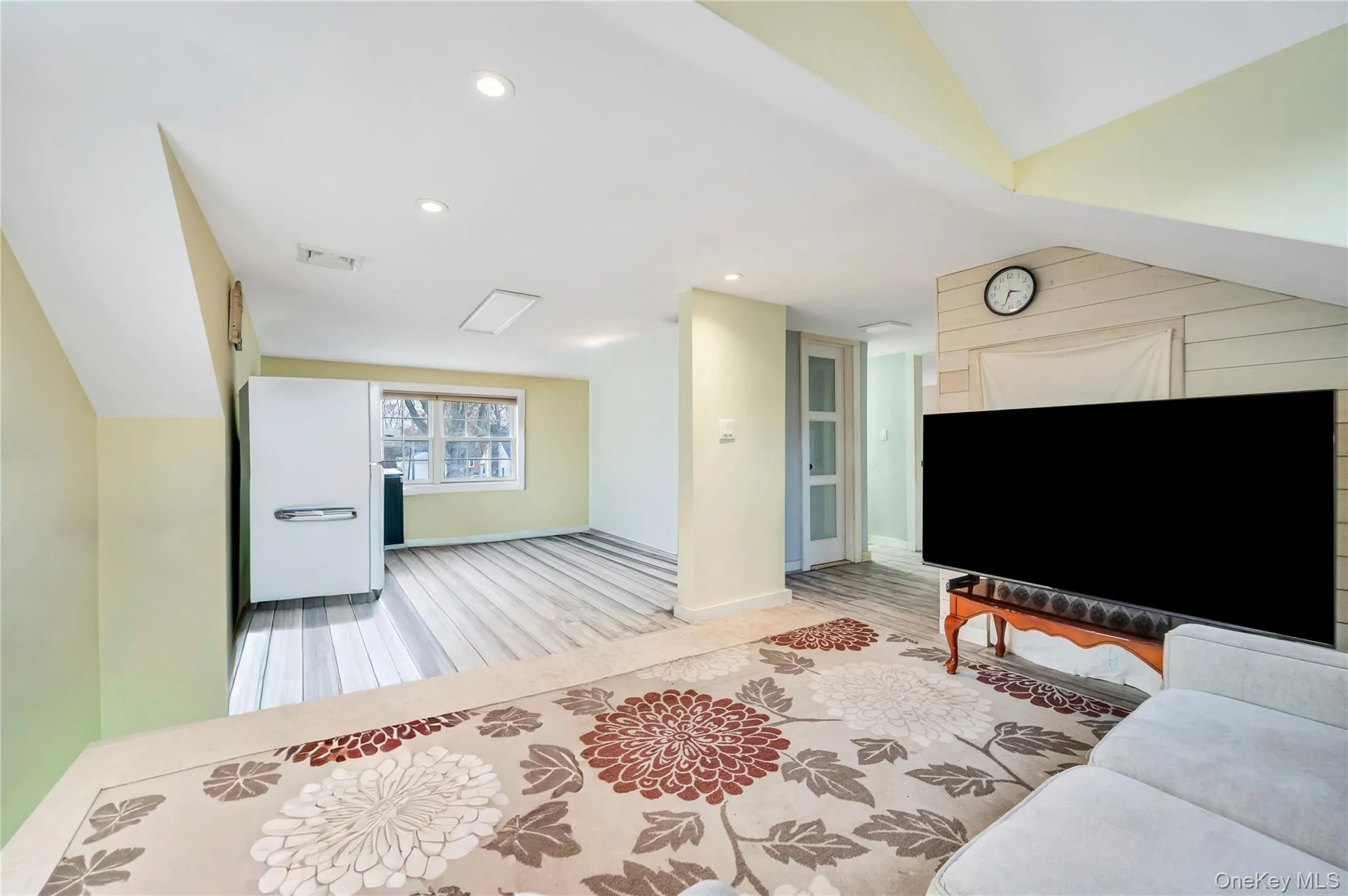 Living area with recessed lighting, light wood finished floors, and lofted ceiling Living area with recessed lighting, light wood finished floors, and lofted ceiling