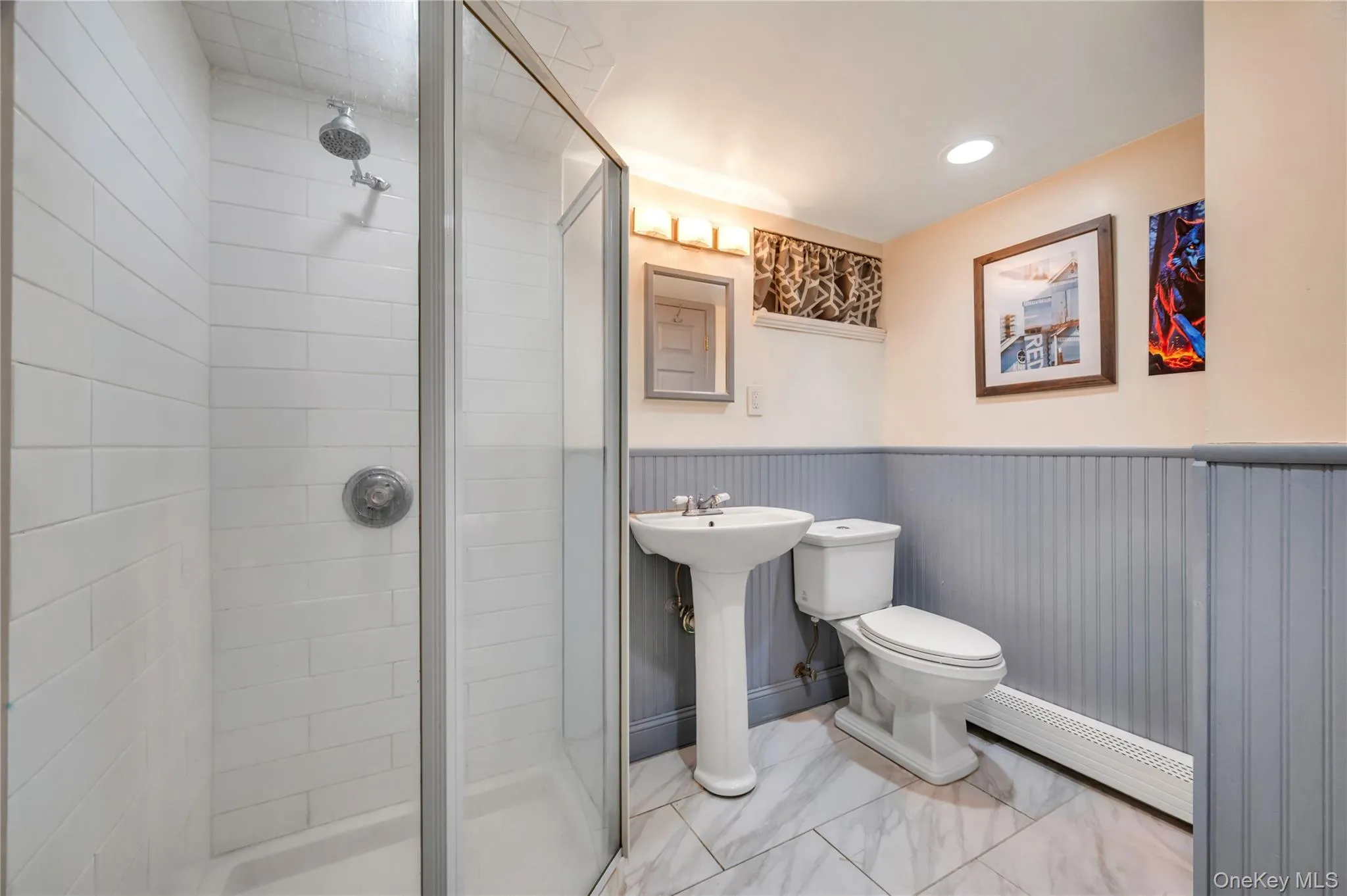 Full bathroom featuring a baseboard radiator, a stall shower, a wainscoted wall, recessed lighting, and marble look tiles Full bathroom featuring a baseboard radiator, a stall shower, a wainscoted wall, recessed lighting, and marble look tiles