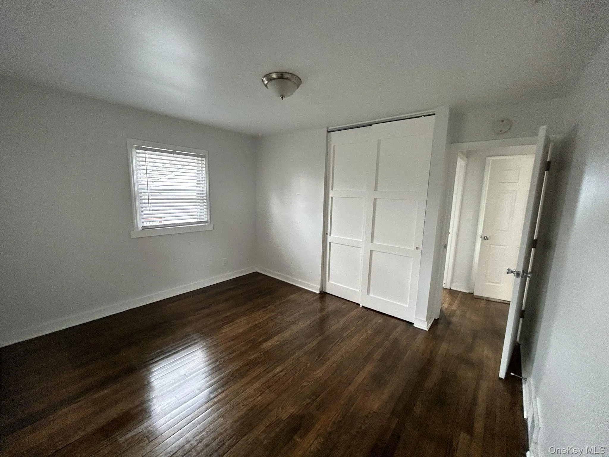 Unfurnished bedroom with dark wood-type flooring and a closet Unfurnished bedroom with dark wood-type flooring and a closet