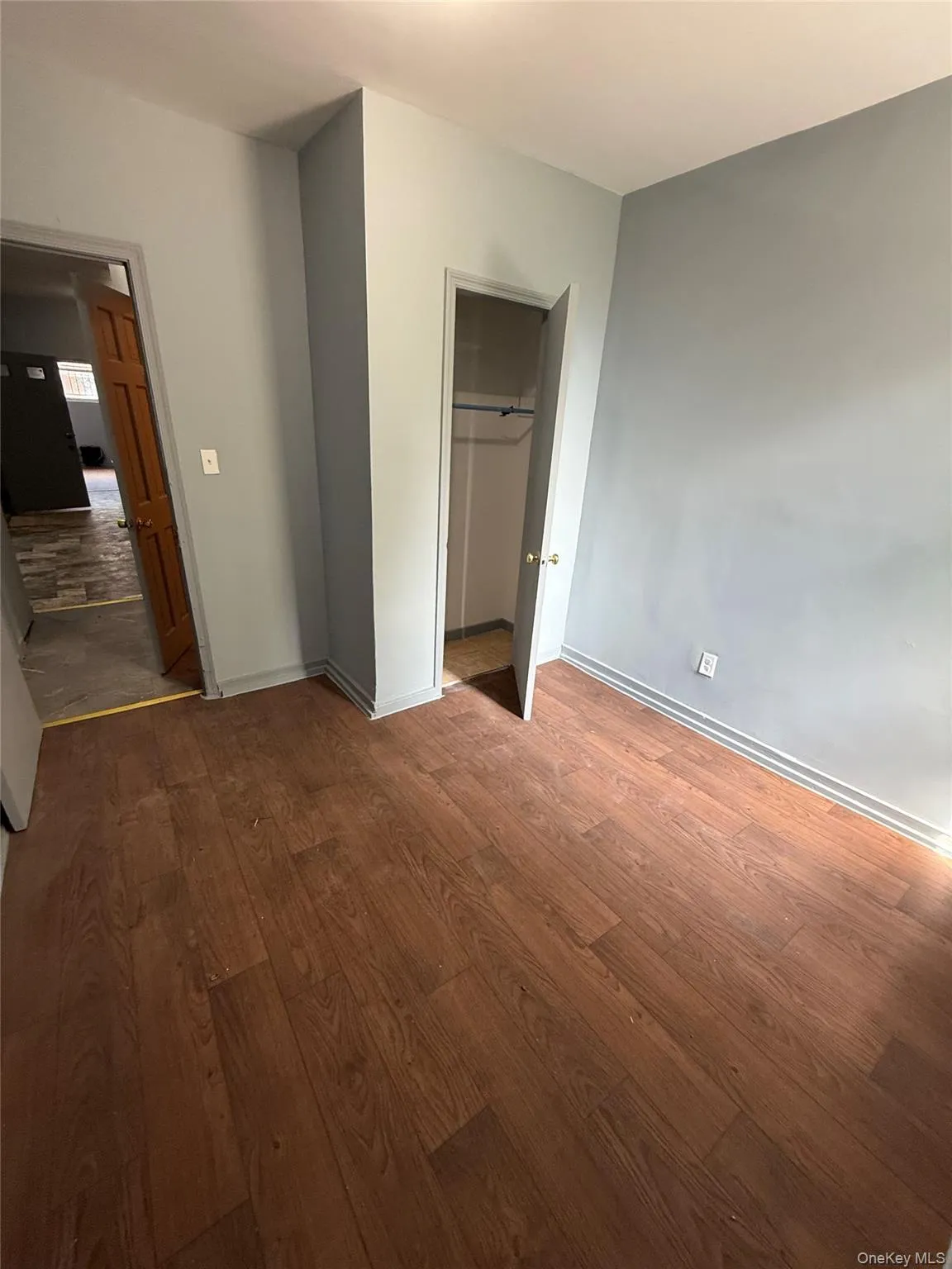 Unfurnished bedroom with wood finished floors and a closet Unfurnished bedroom with wood finished floors and a closet