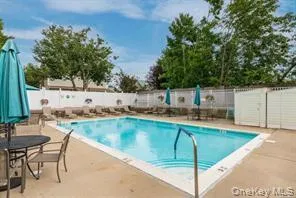 Community pool with a patio and a fenced backyard Community pool with a patio and a fenced backyard