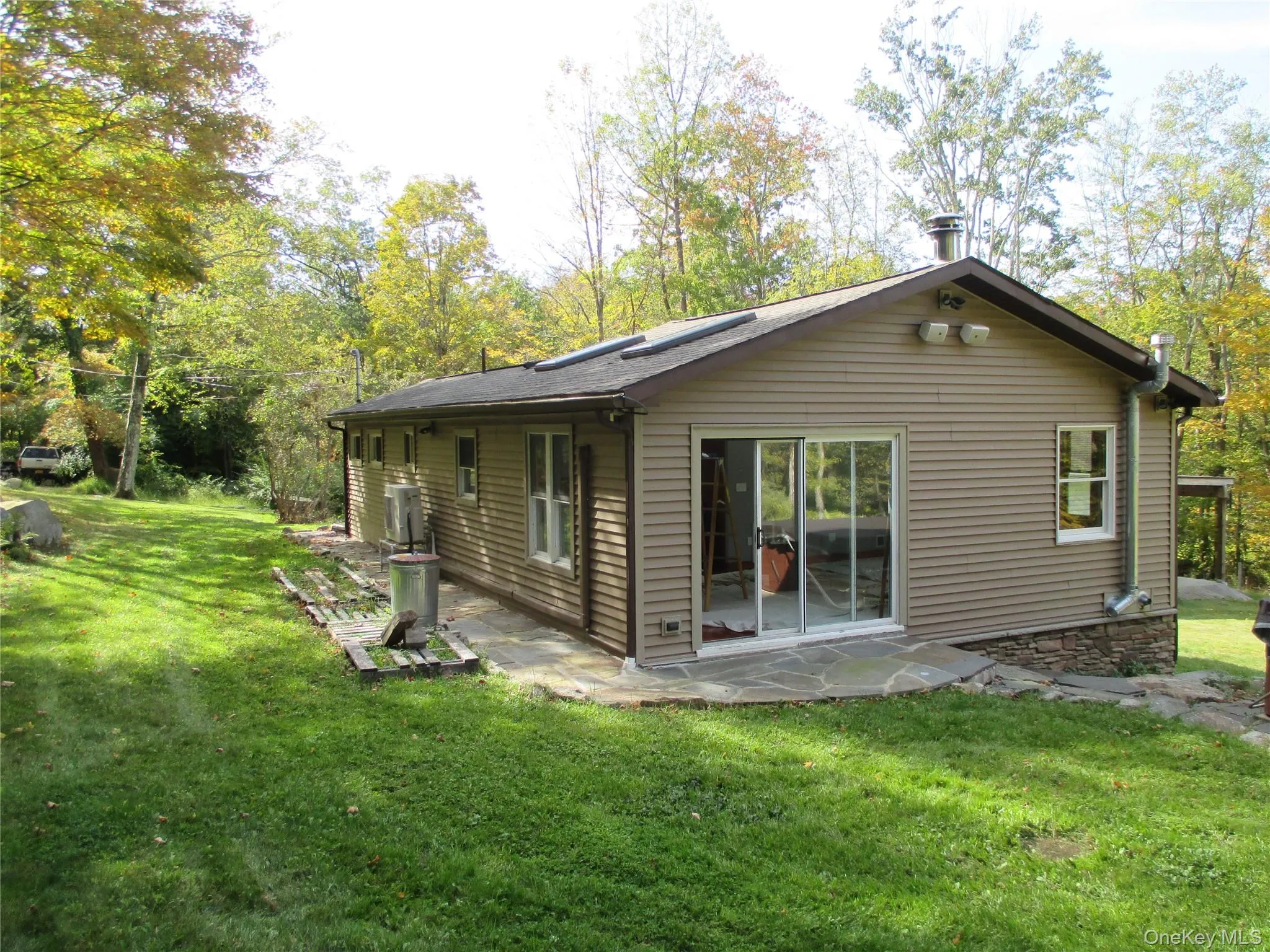 Rear view of house with a lawn and a patio area Rear view of house with a lawn and a patio area